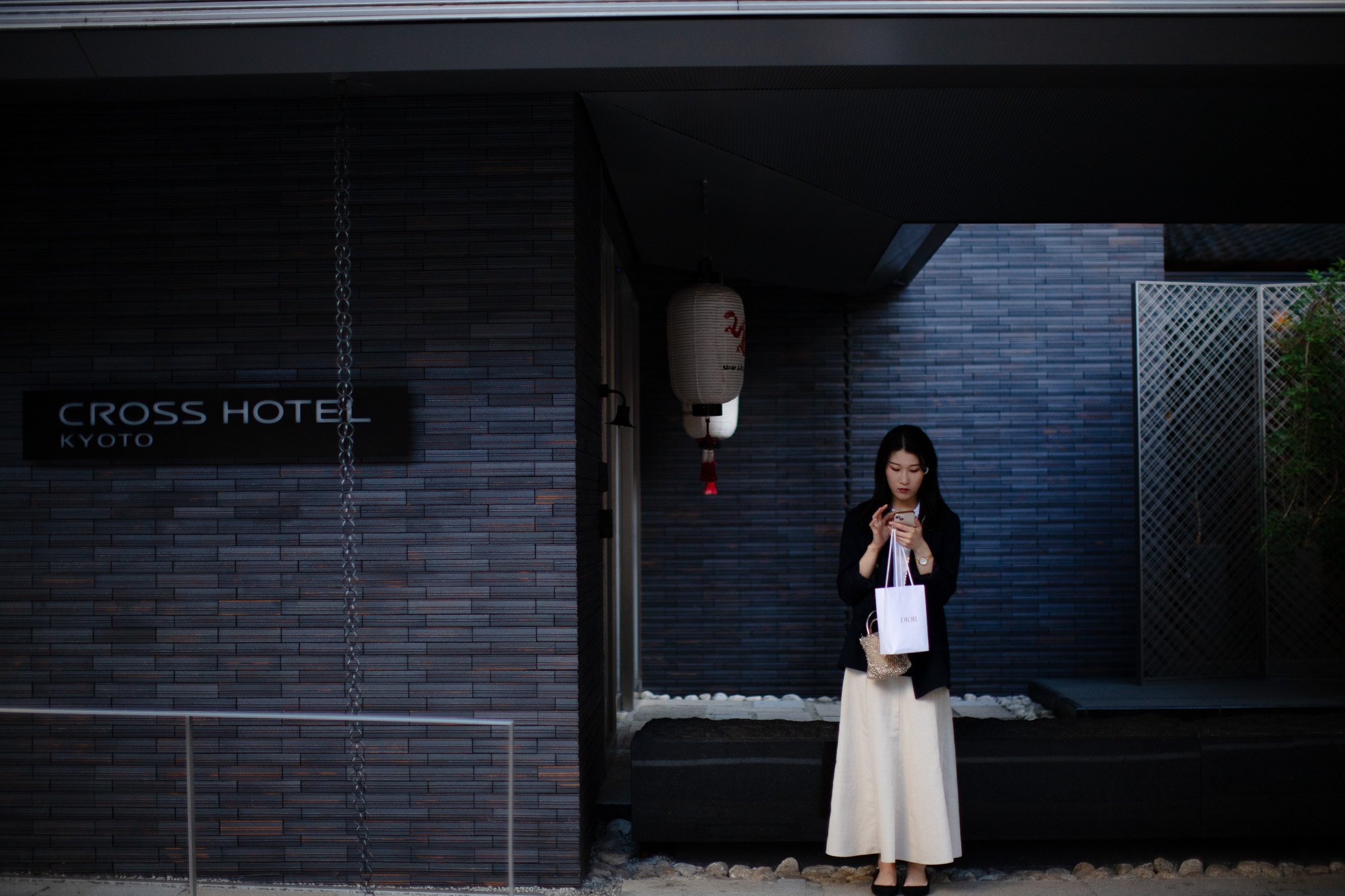 kushphoto-kyoto-woman-phone-hotel-entrance-2024.jpg