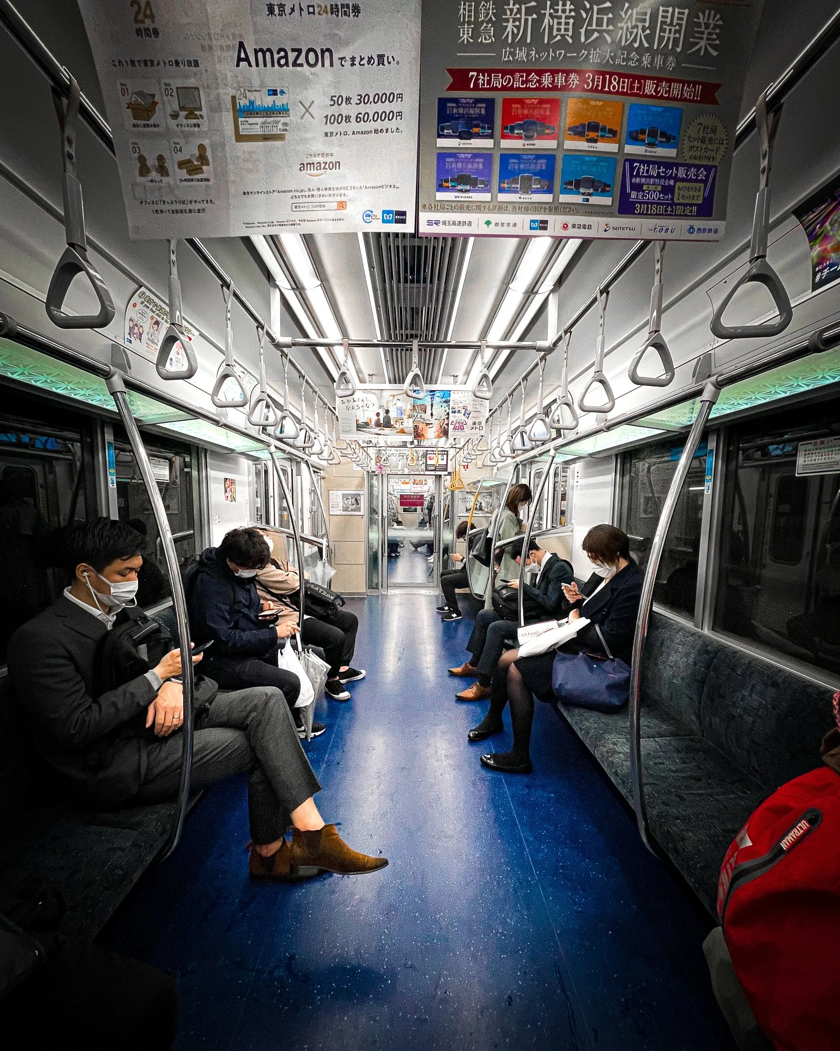 Commuters in a symmetric metro car, Tokyo, 2023