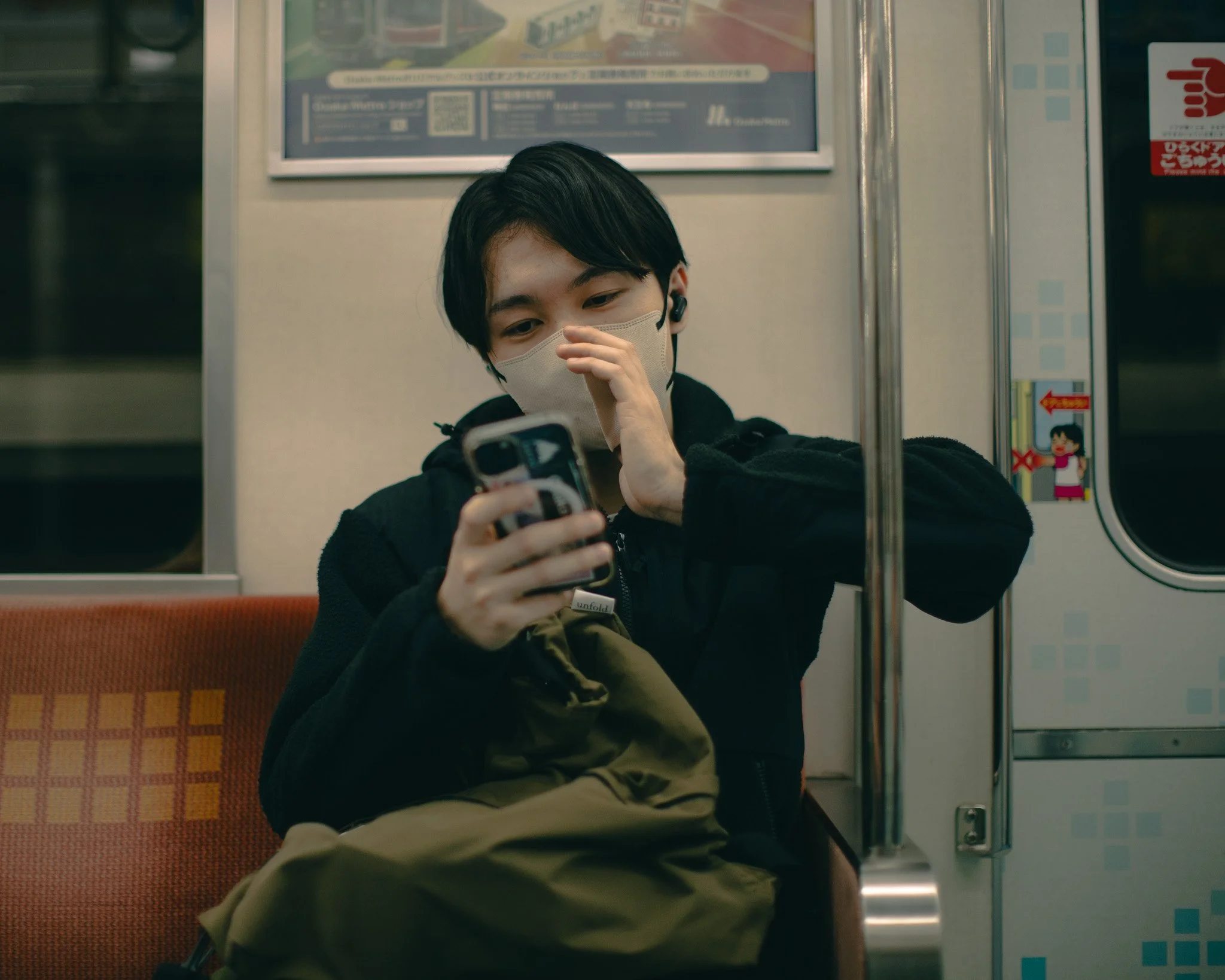 kushphoto-osaka-masked-man-phone-train-2025.jpg