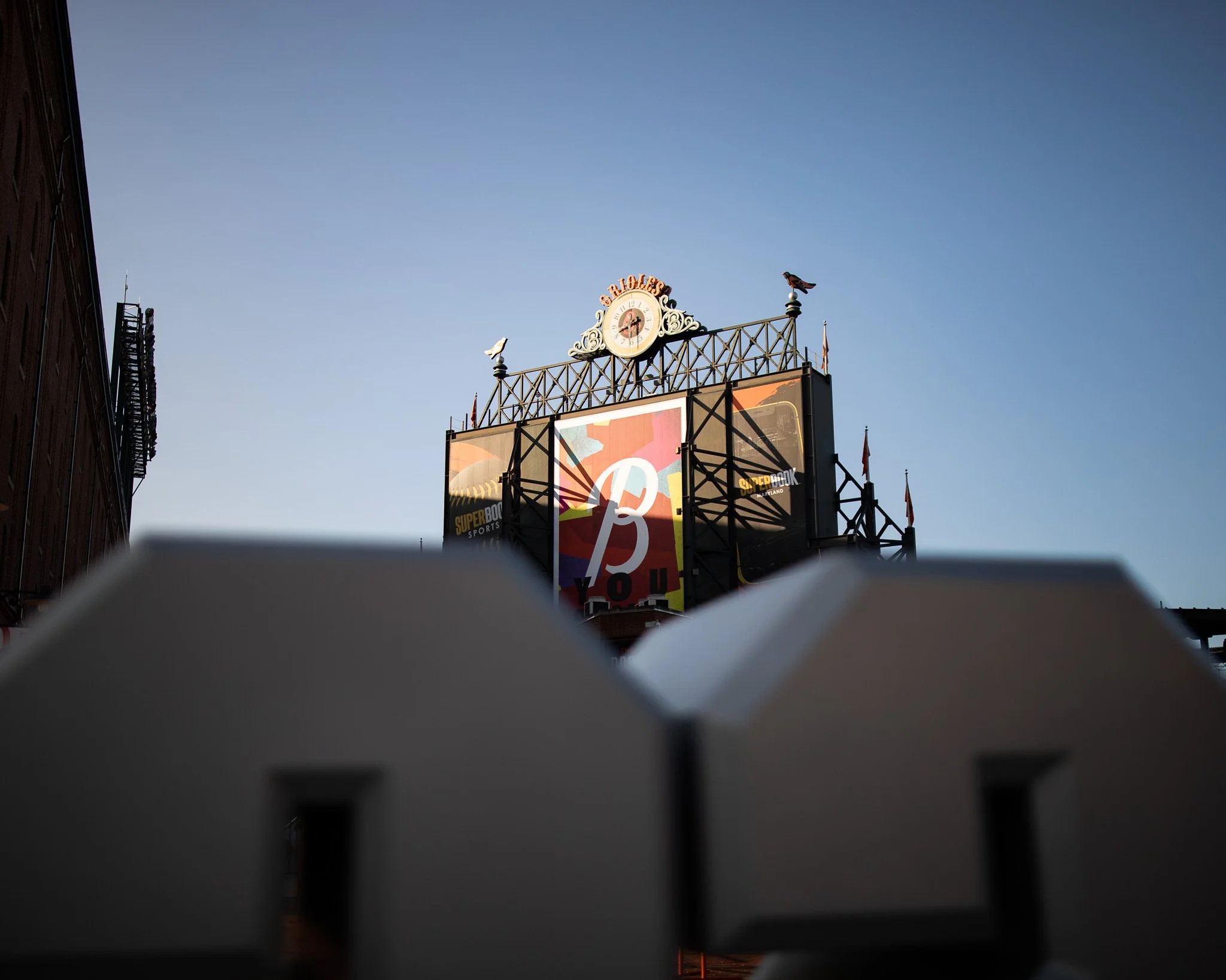 Orioles scoreboard clock catching the light, Baltimore, 2023
