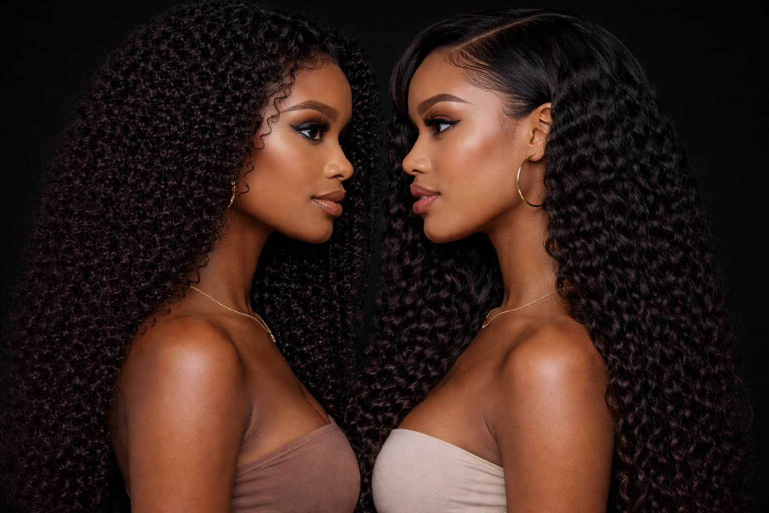 Two women with curly hair face each other against a black background, both wearing strapless tops and gold jewelry.