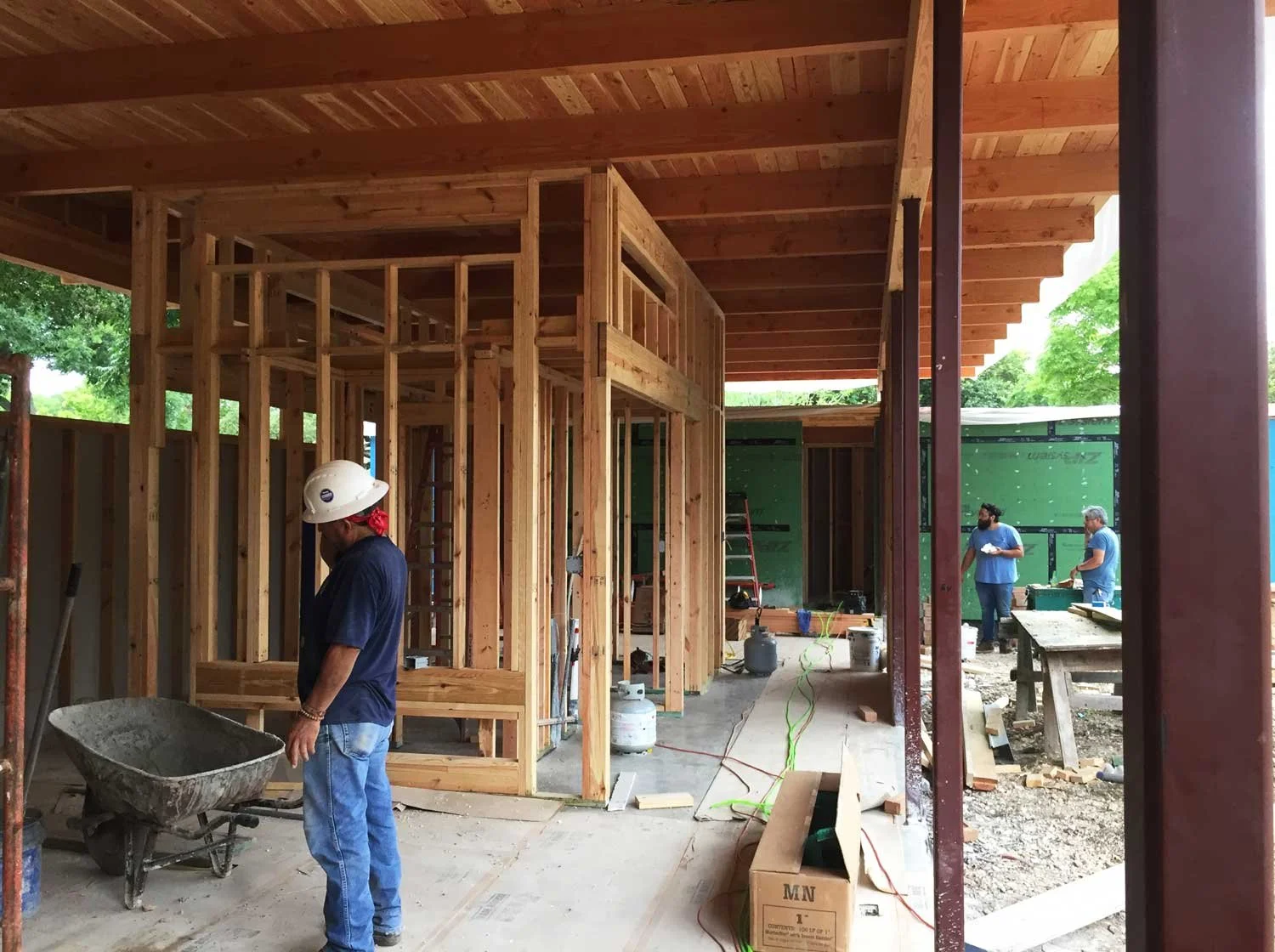 Construction workers working on framing a house under construction.