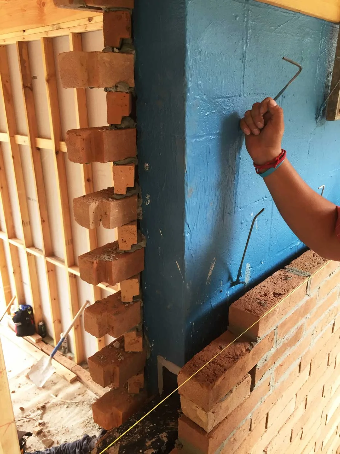 Close-up view of a brick wall corner detail under construction.