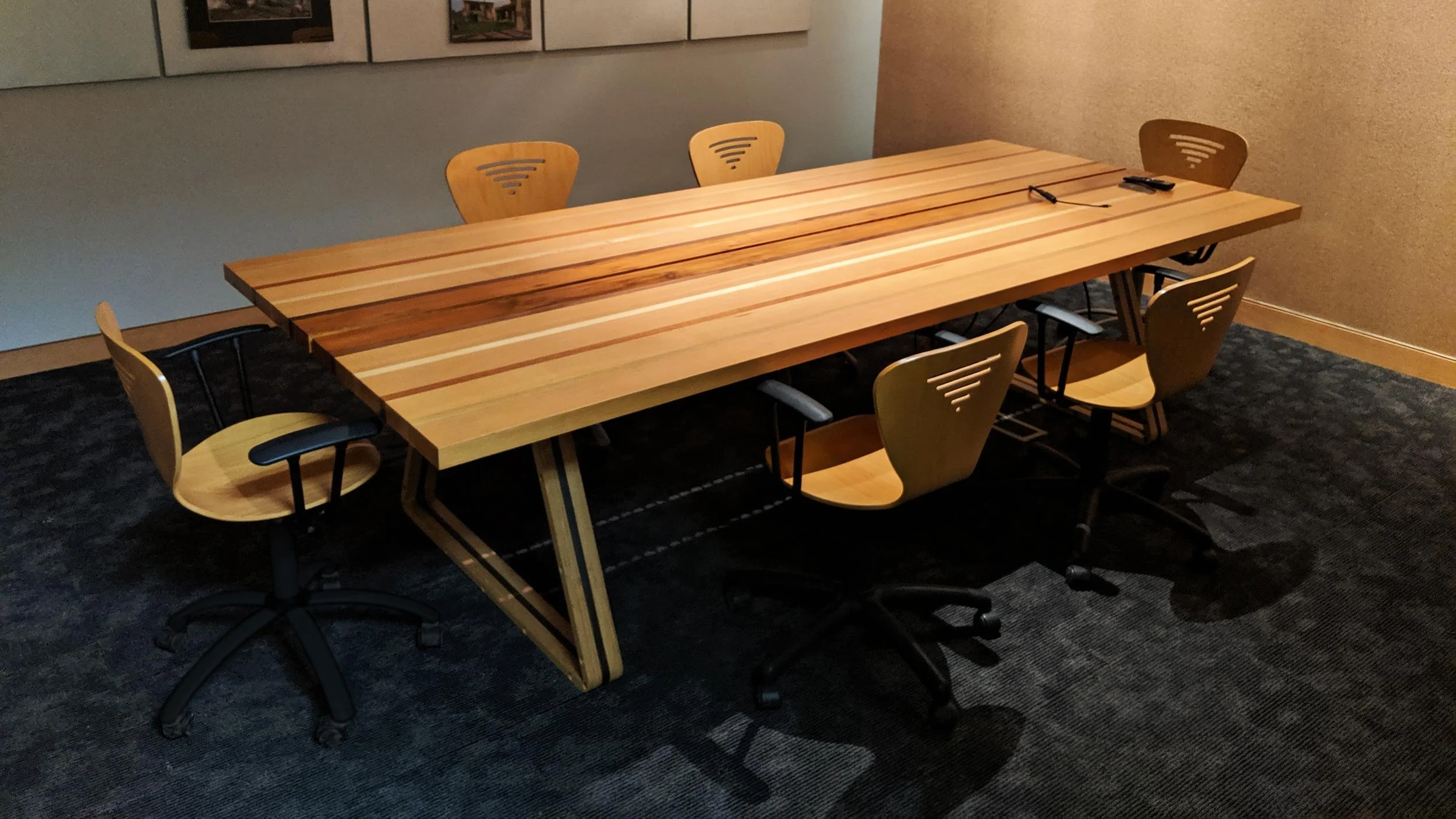 A wooden conference table surrounded by six wooden chairs.