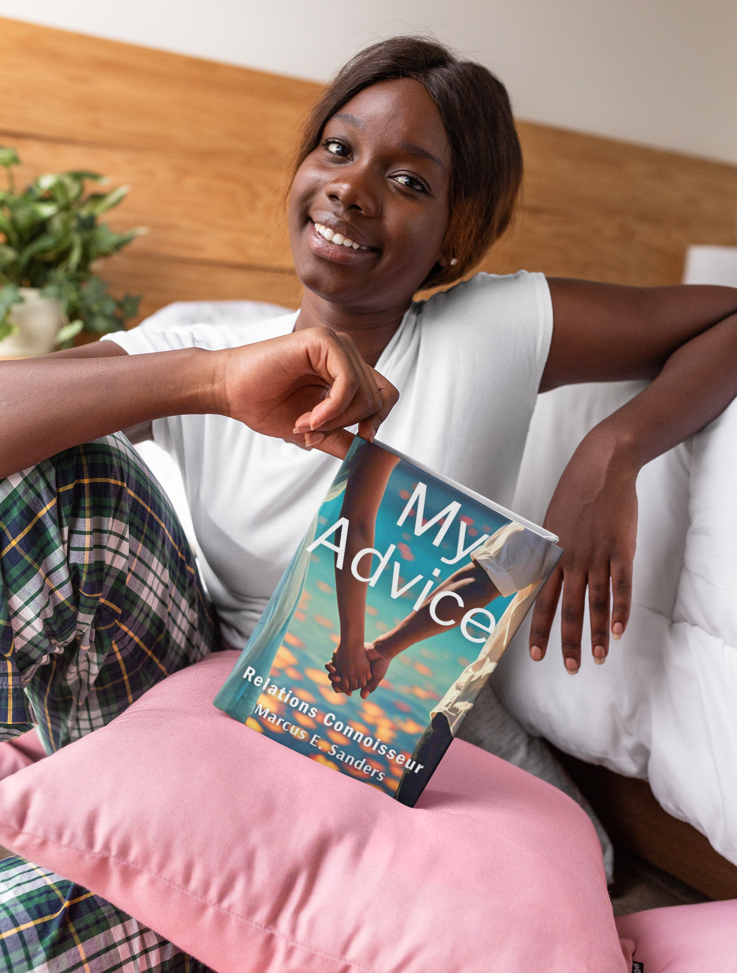 mockup-of-a-smiling-woman-holding-a-hard-cover-book-against-a-pillow-23710.png