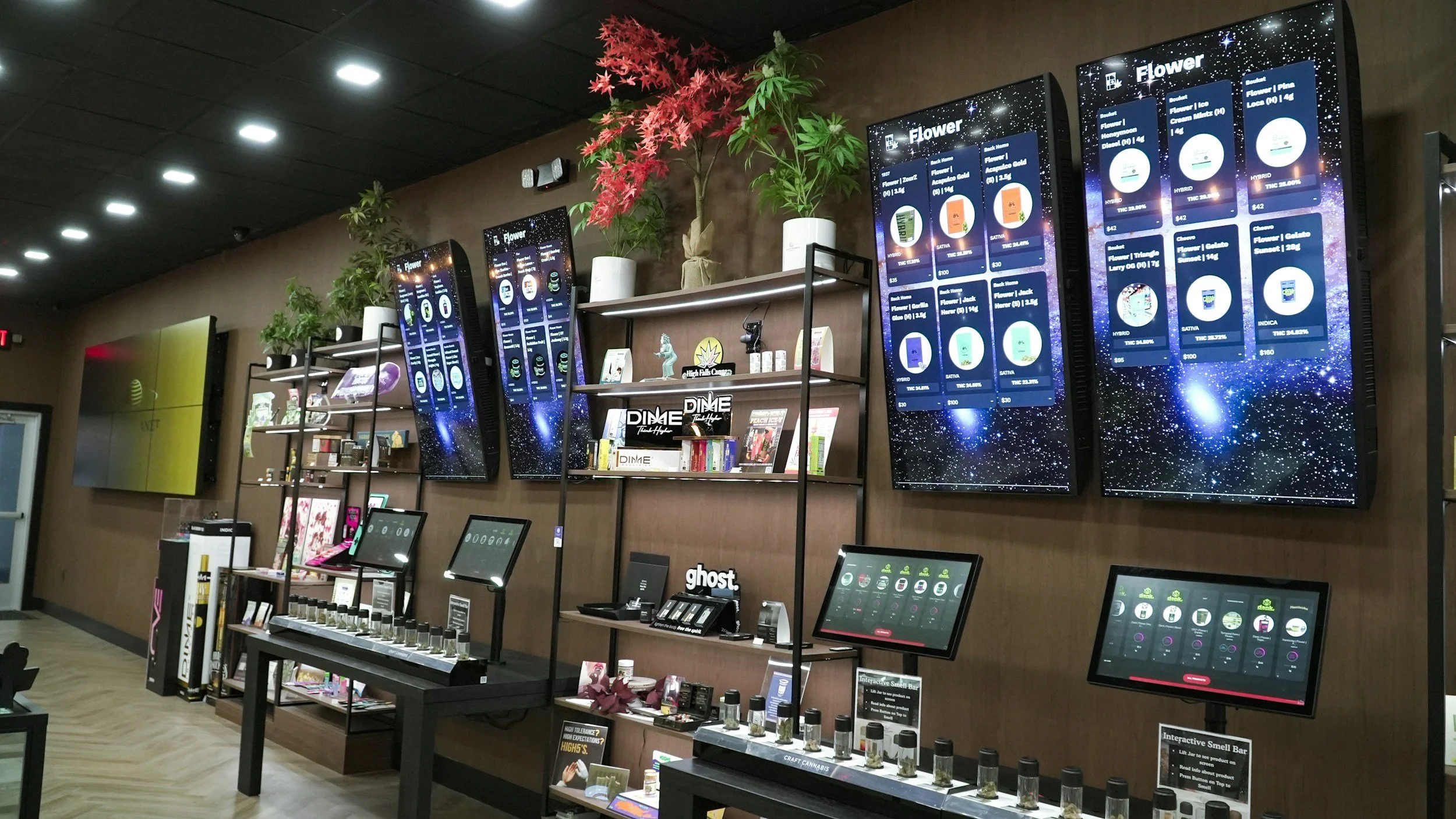 Display wall in a retail store showing digital menus with various products offered, along with actual products and informational screens.