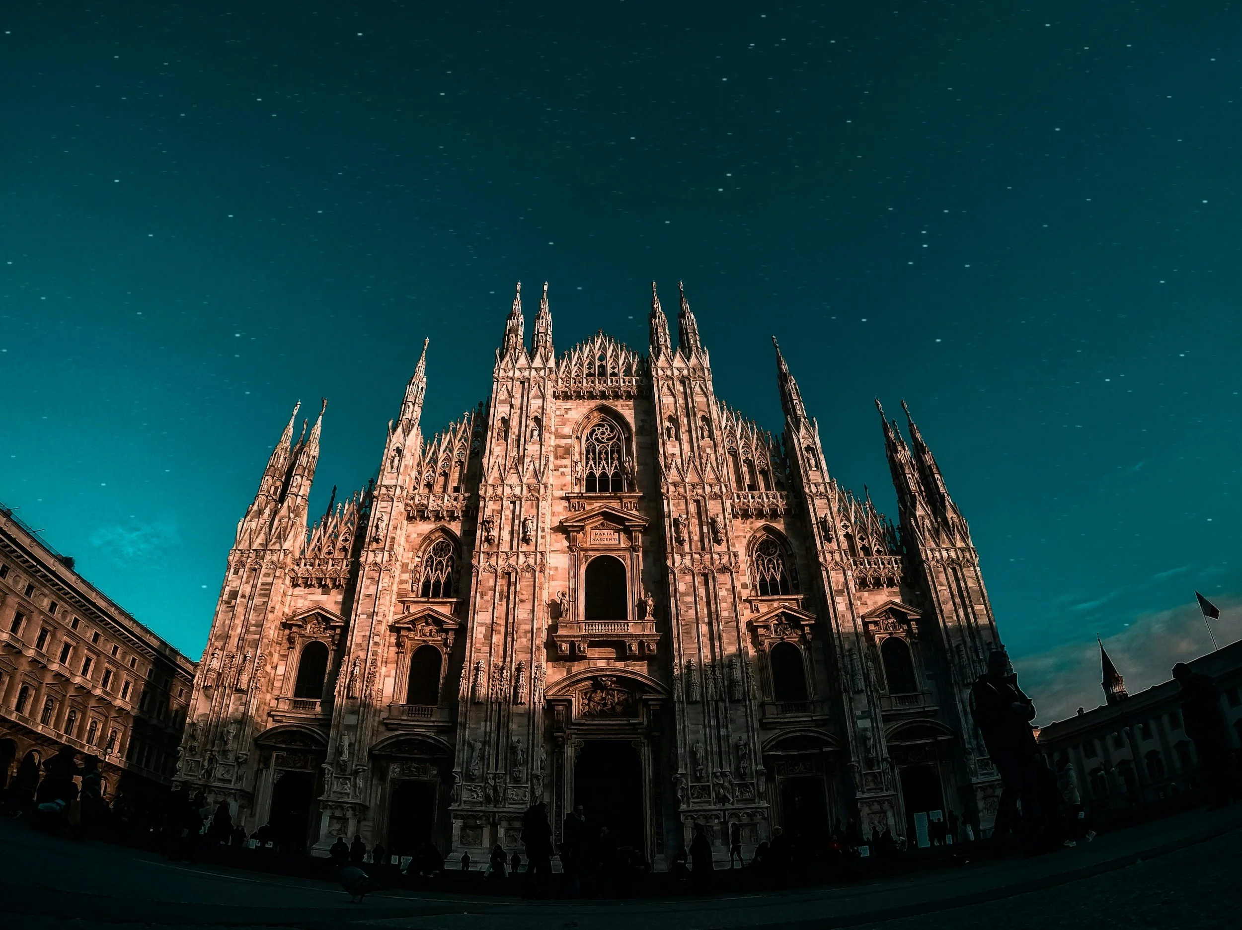 Gothic cathedral with pointed arches and tall spires, under a starry sky at night.