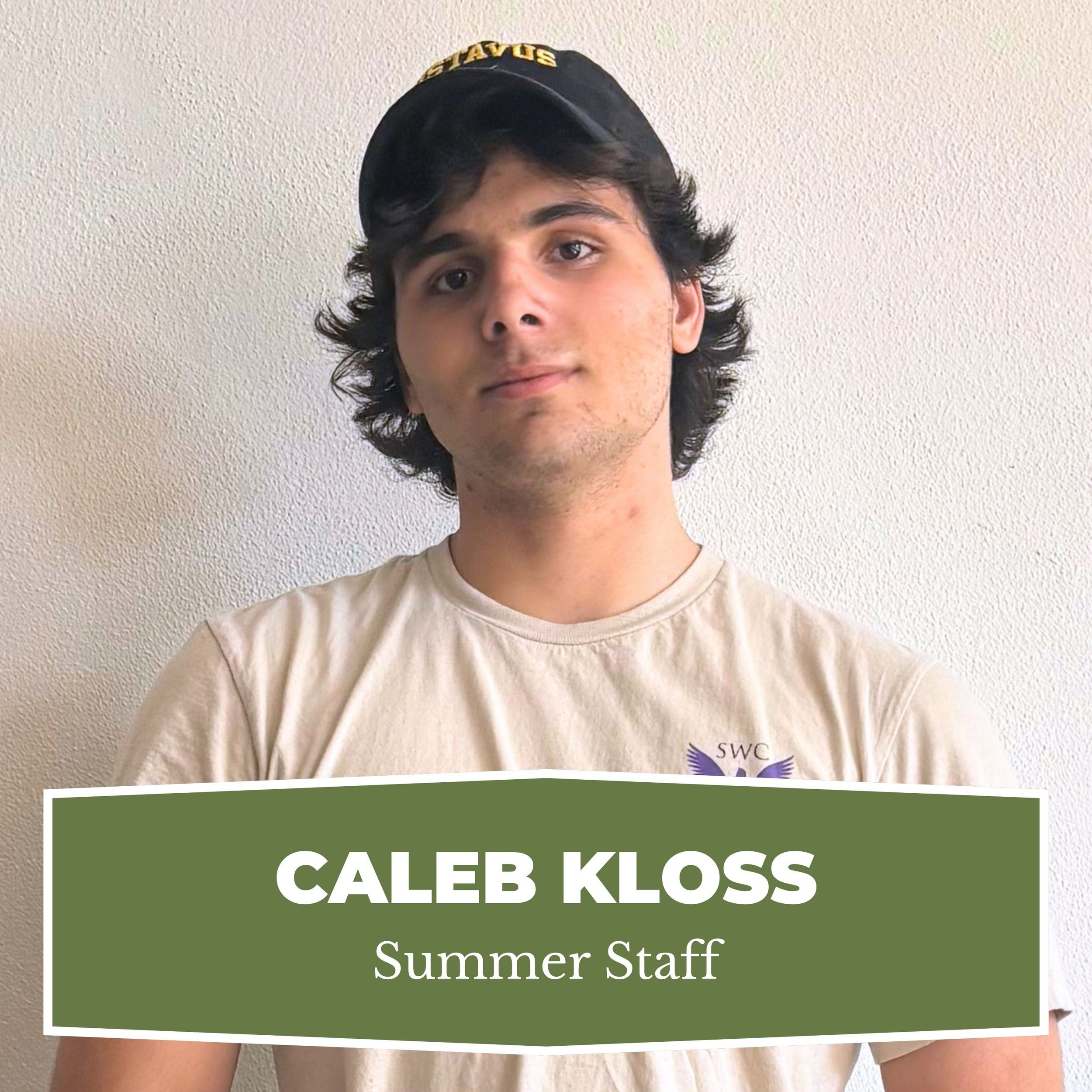 Young man with dark hair wearing a beige t-shirt and a black cap, standing against a plain wall, with a text overlay that reads 'Caleb Kloss, Summer Staff'.
