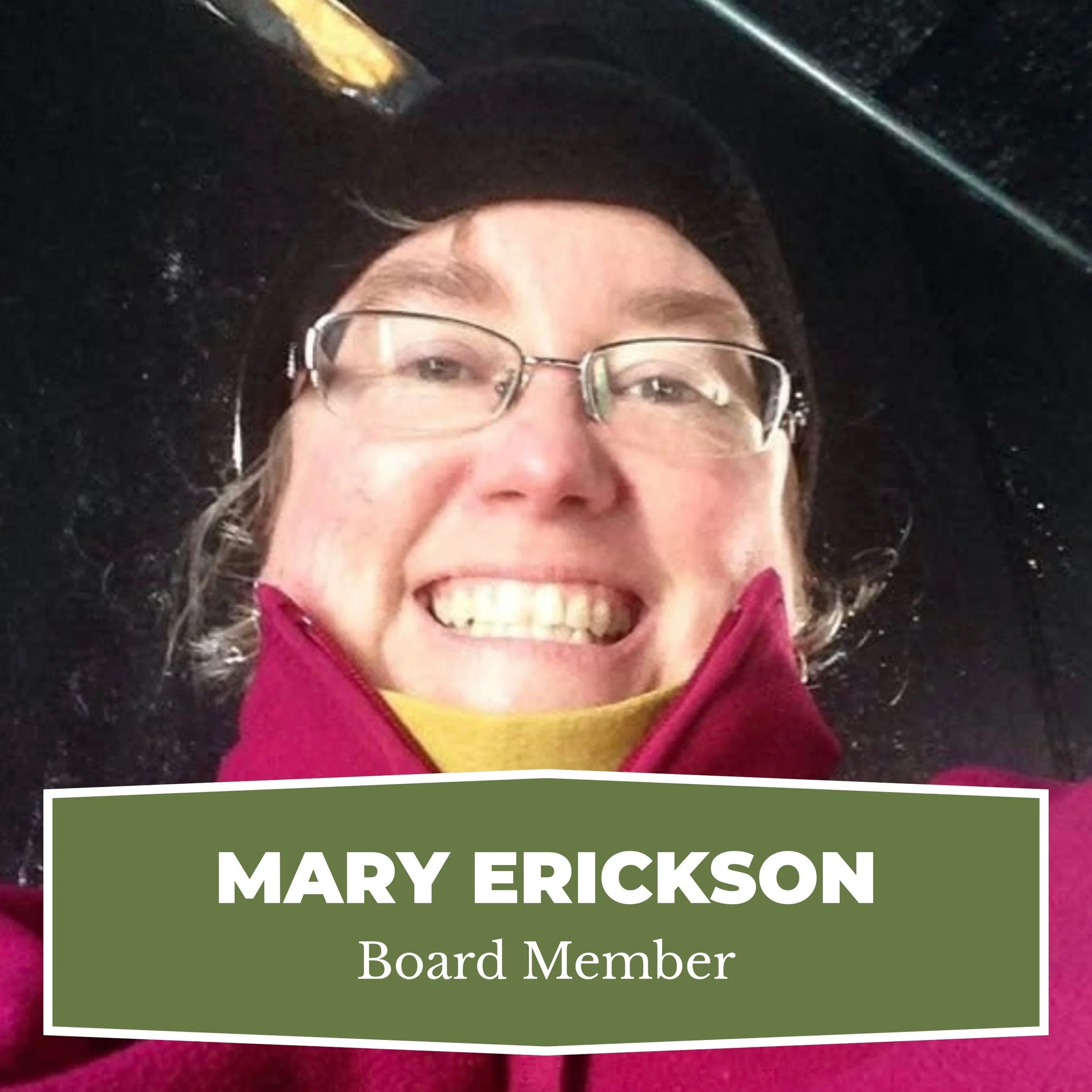Close-up photo of a woman smiling, wearing glasses, a dark hat, and a maroon jacket, with a name badge that reads 'Mary Erickson, Board Member'.
