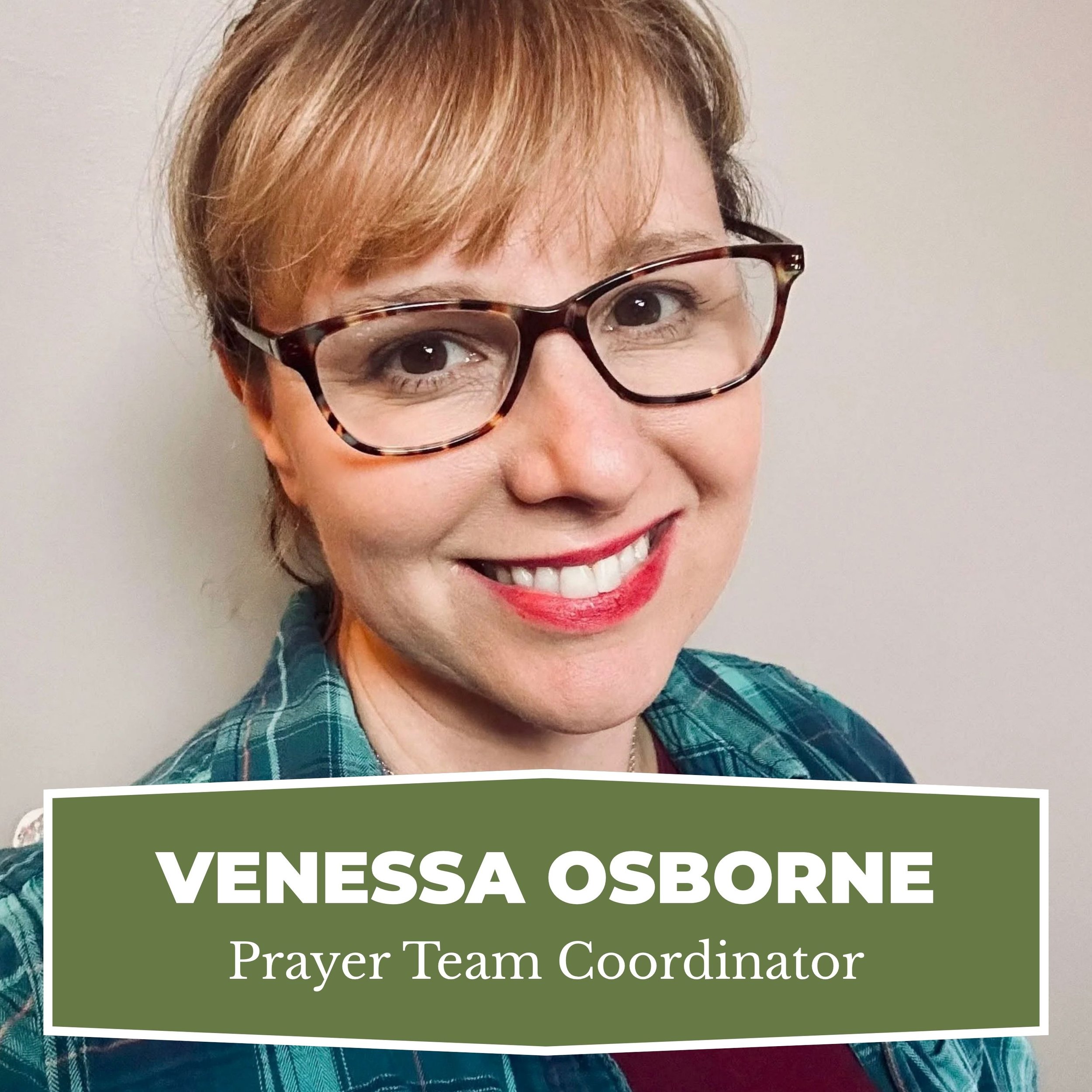 A smiling woman with short light brown hair, glasses, red lipstick, wearing a plaid shirt and a maroon top, standing against a plain wall. Text overlay reads: 'Venessa Osborne, Prayer Team Coordinator.'