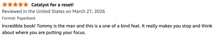 Book review for a paperback titled 'Catalyst for a reset!' with a 5-star rating, reviewed in the United States on March 27, 2026. The review mentions Tommy, describing him as the man, and comments on the book's impactful nature.