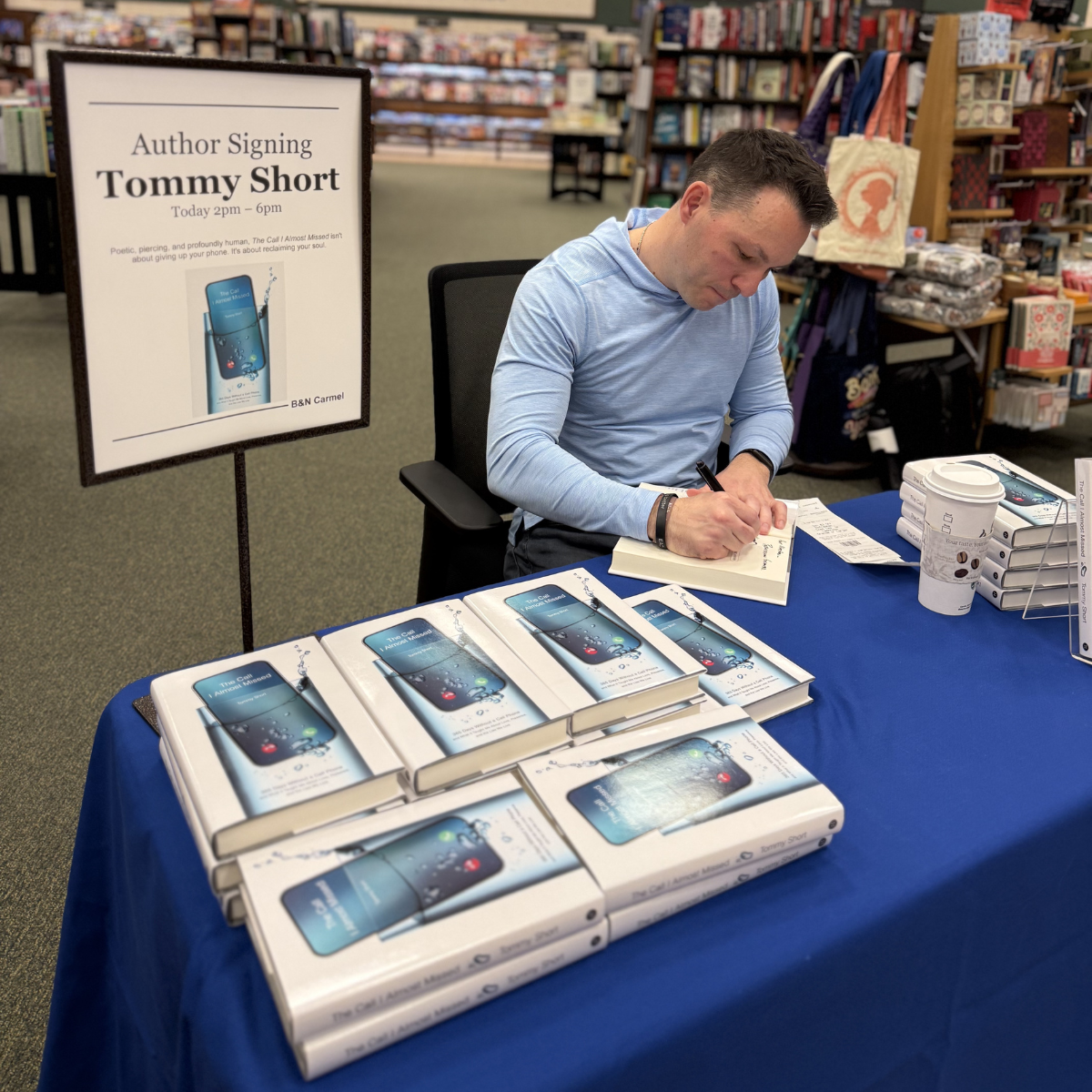 Author Tommy Short signing copies of his book titled 'The Call I Almost Missed' at a bookstore event, with several copies of the book displayed on a table.