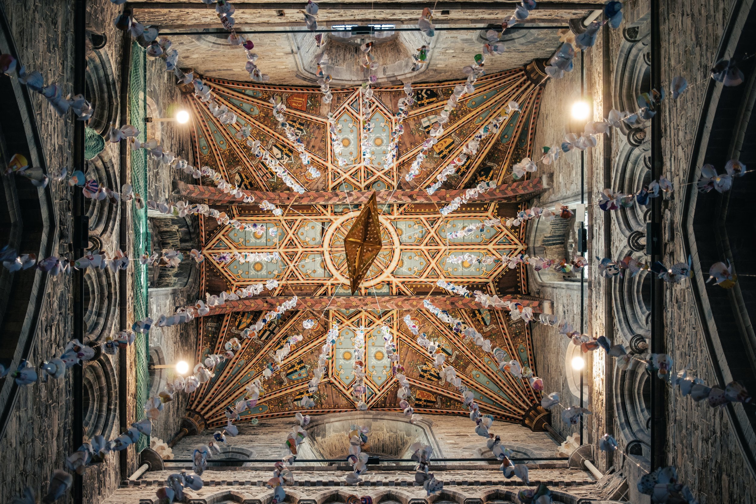 St Davids Cathedral interior in Pembrokeshire with painted ceiling and hanging decorations