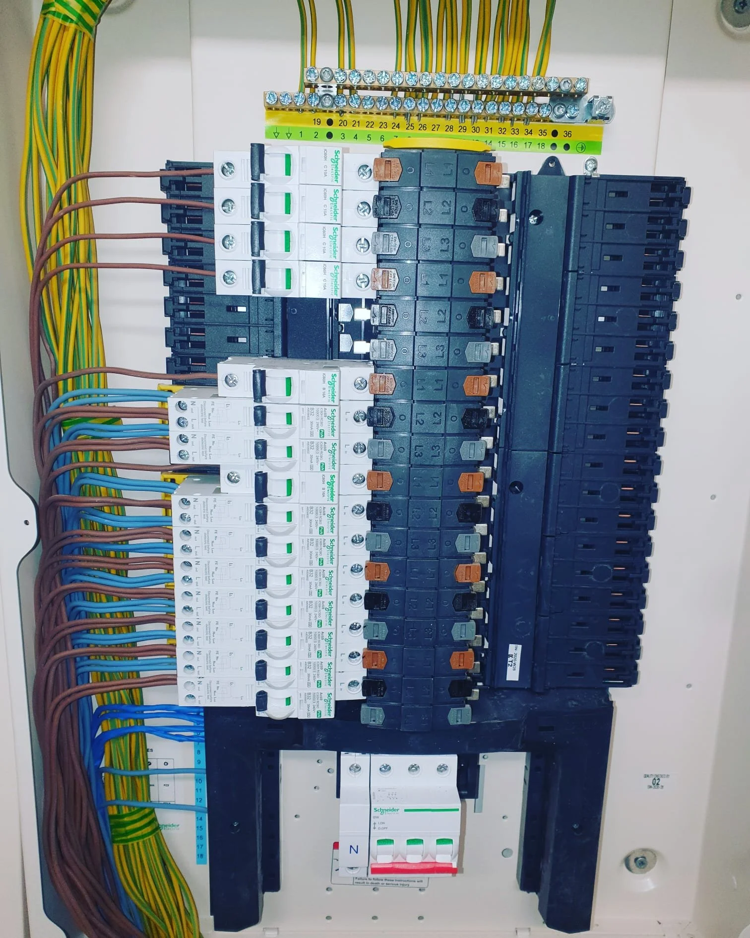 Electrical panel with circuit breakers, wiring, and terminal connections.
