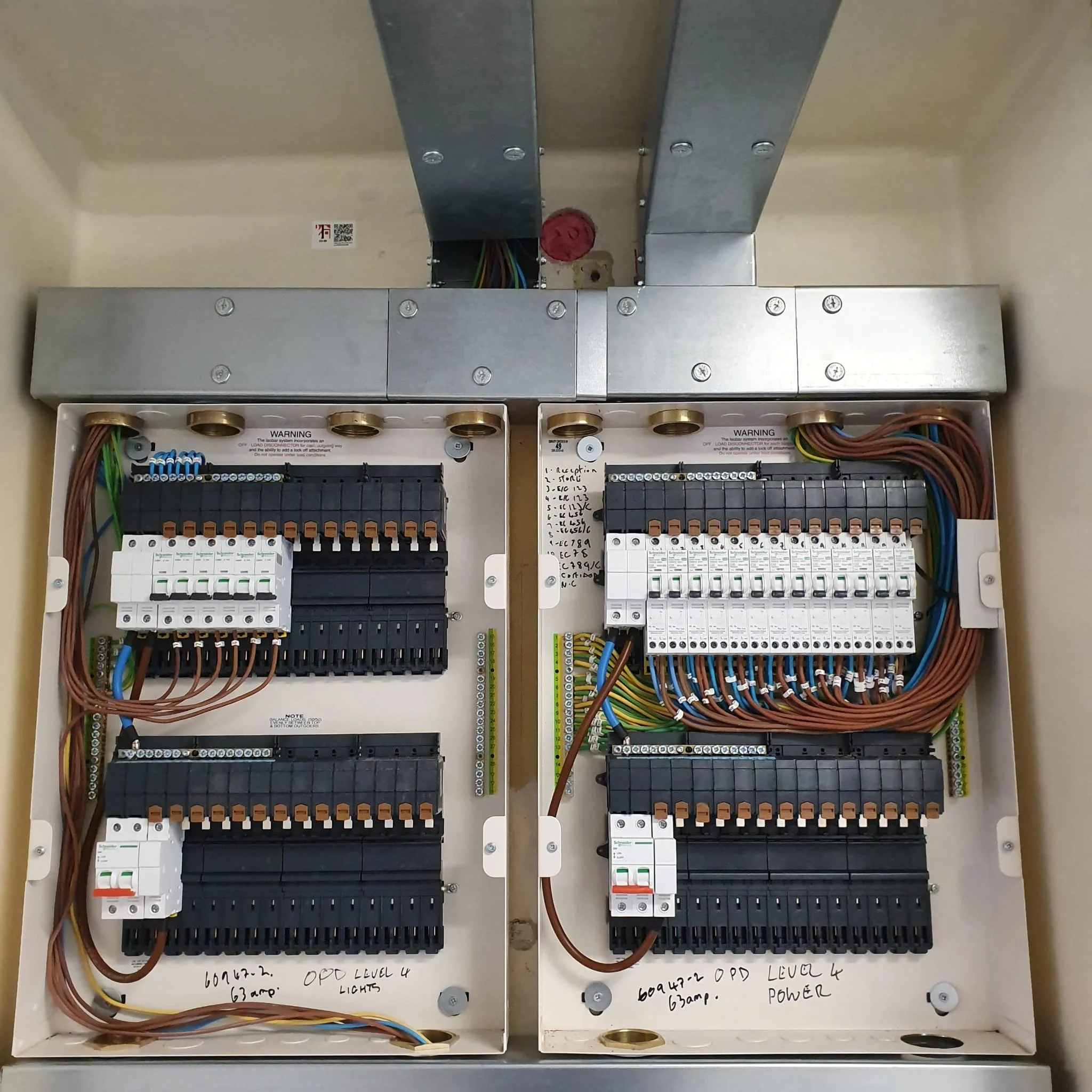 Electrical control panel with various wires, circuit breakers, and components organized inside an open metal box.