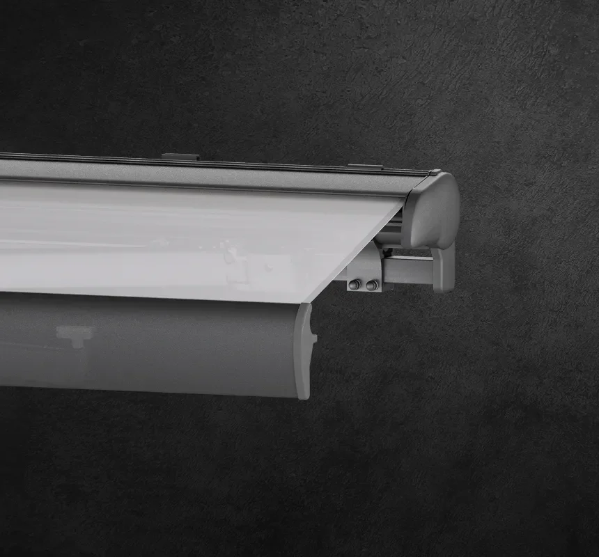 Close-up of a gray retractable awning with its side mounting bracket against a dark textured wall