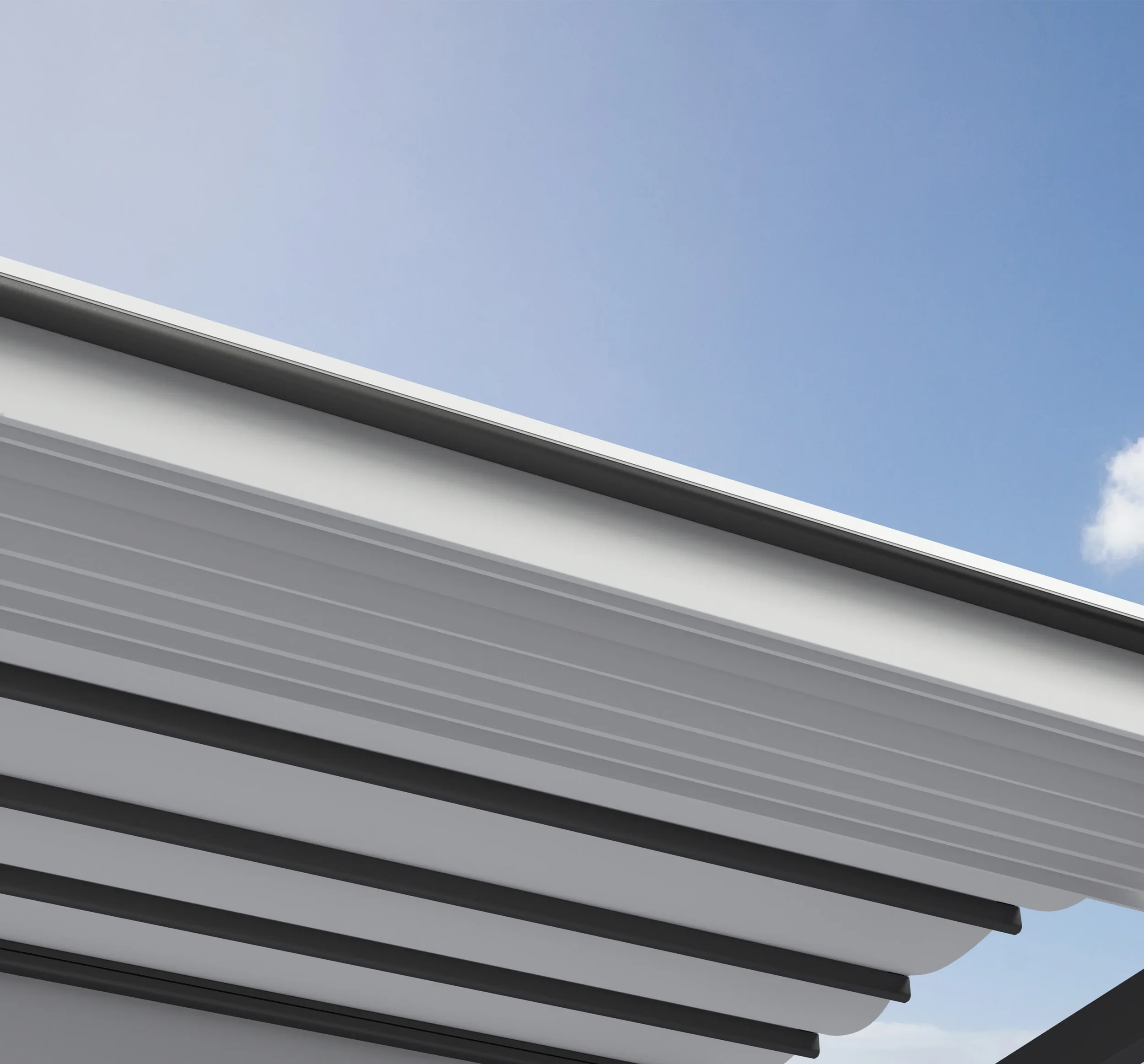 Low-angle view of a modern building’s layered gray roof overhang against a blue sky