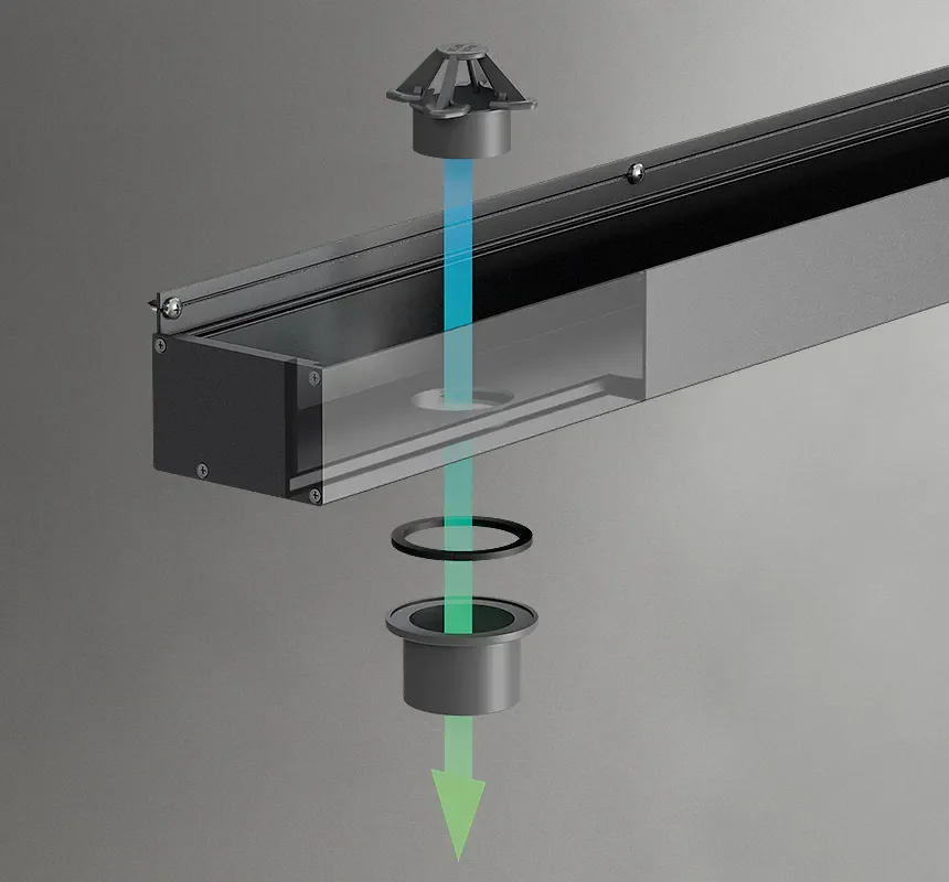 Exploded diagram of a linear drain showing a removable grate, drain channel, sealing ring, outlet fitting, and downward water flow.