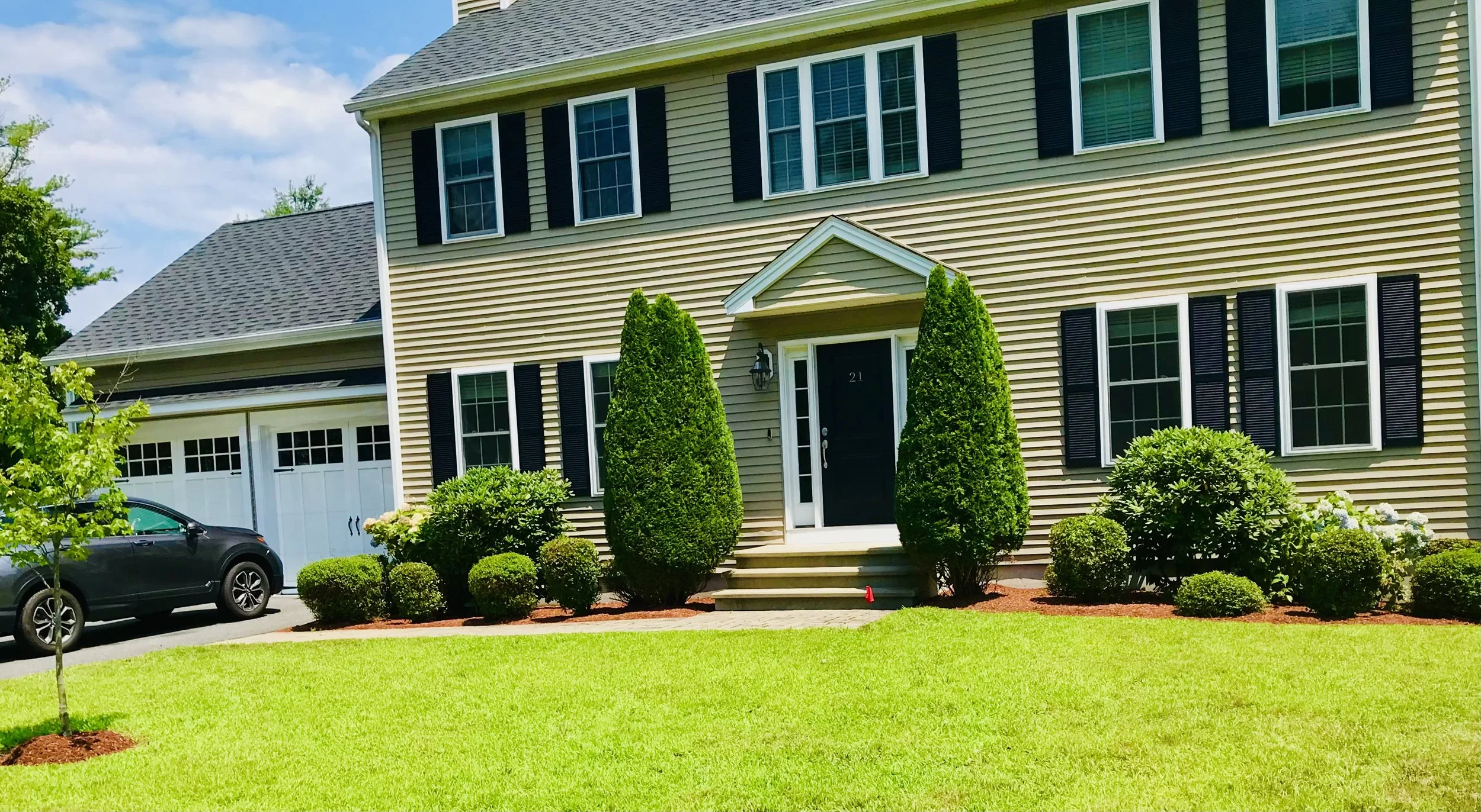 Front yard landscaping with lawn care, shrub planting, and property maintenance in Metrowest Boston Home. (Framingham, MA)