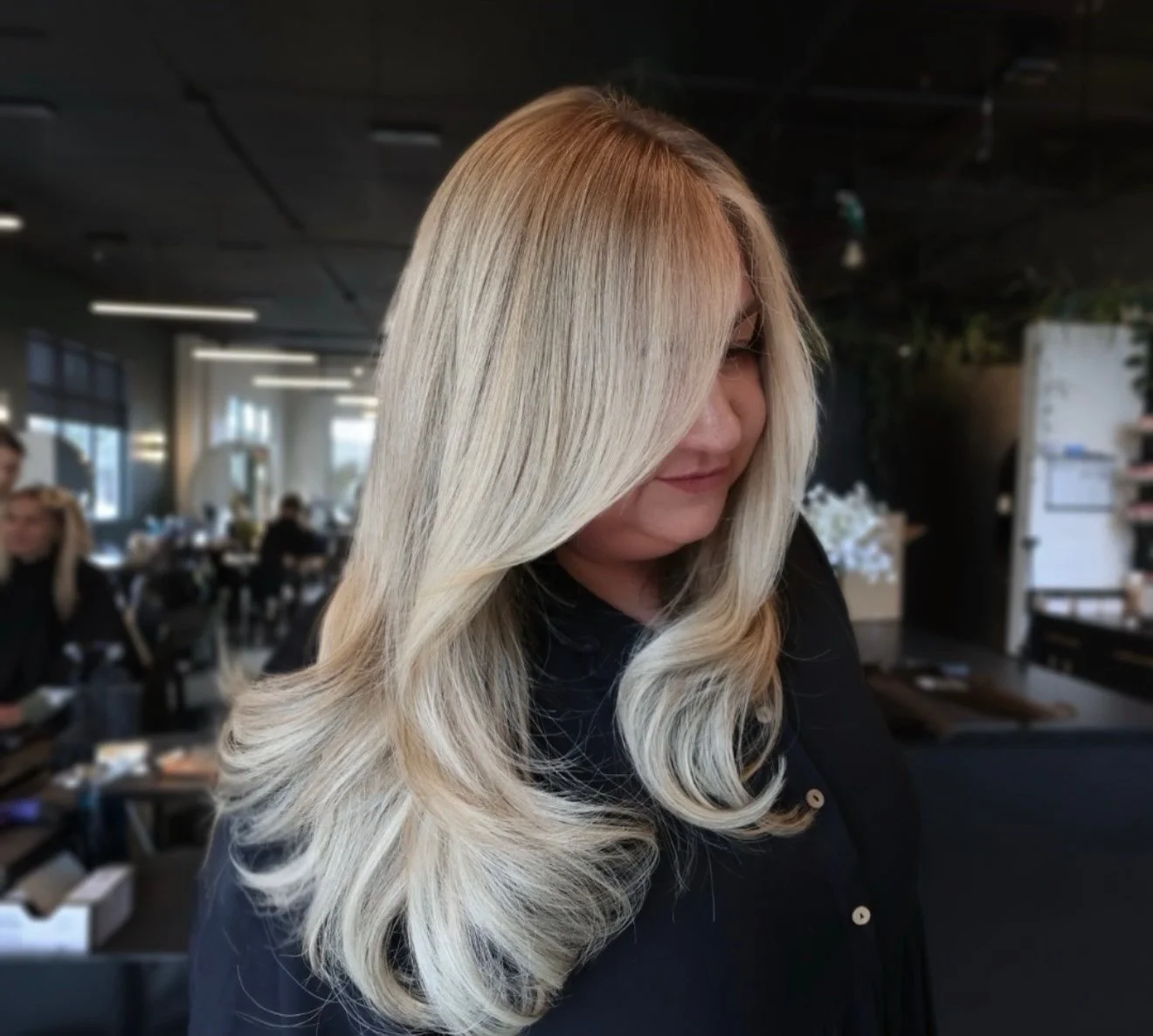 A woman with long, wavy blonde hair in a salon.