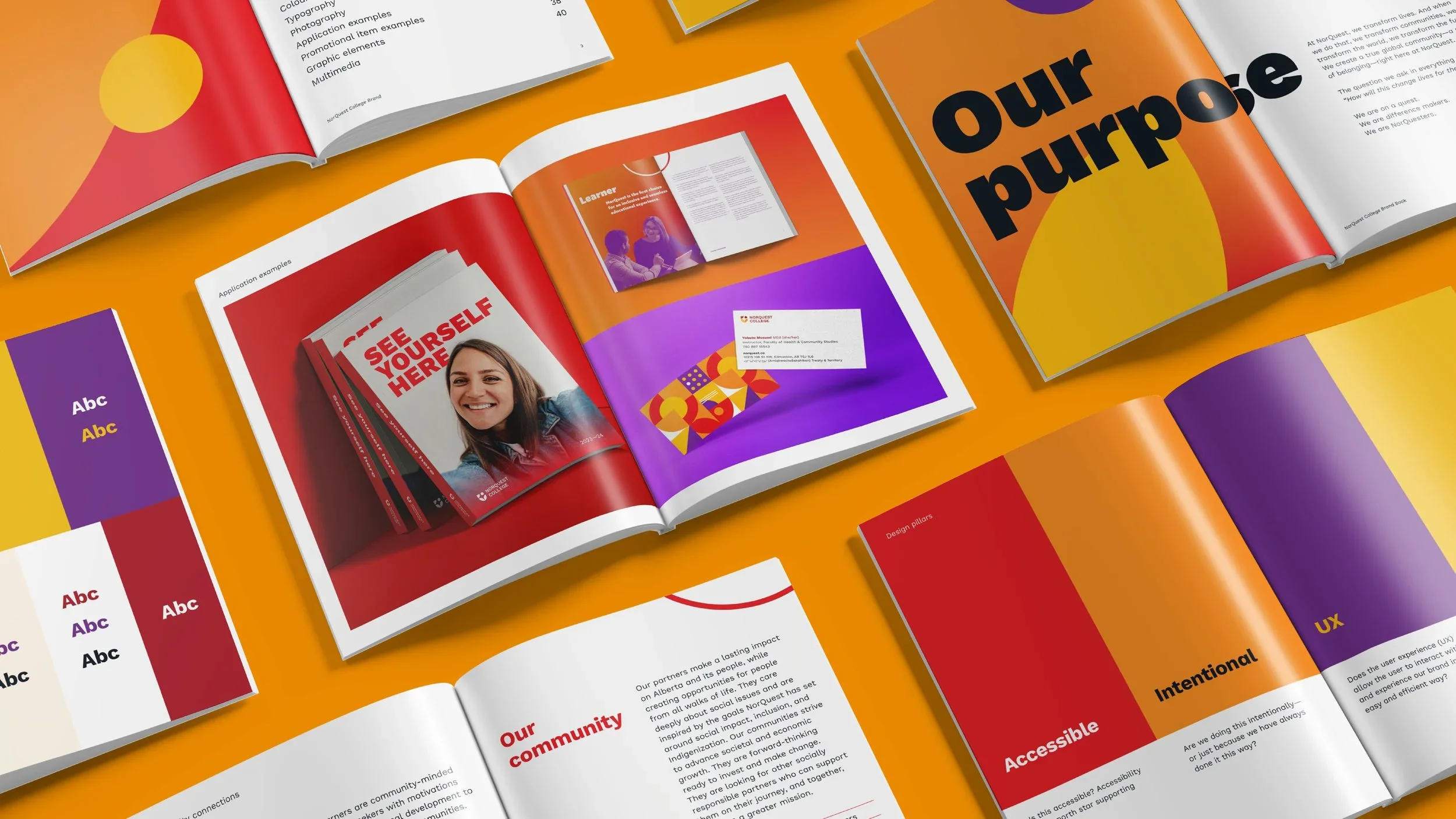 Open magazine pages on an orange table displaying colorful graphics and text about purpose, community, accessibility, and design elements.