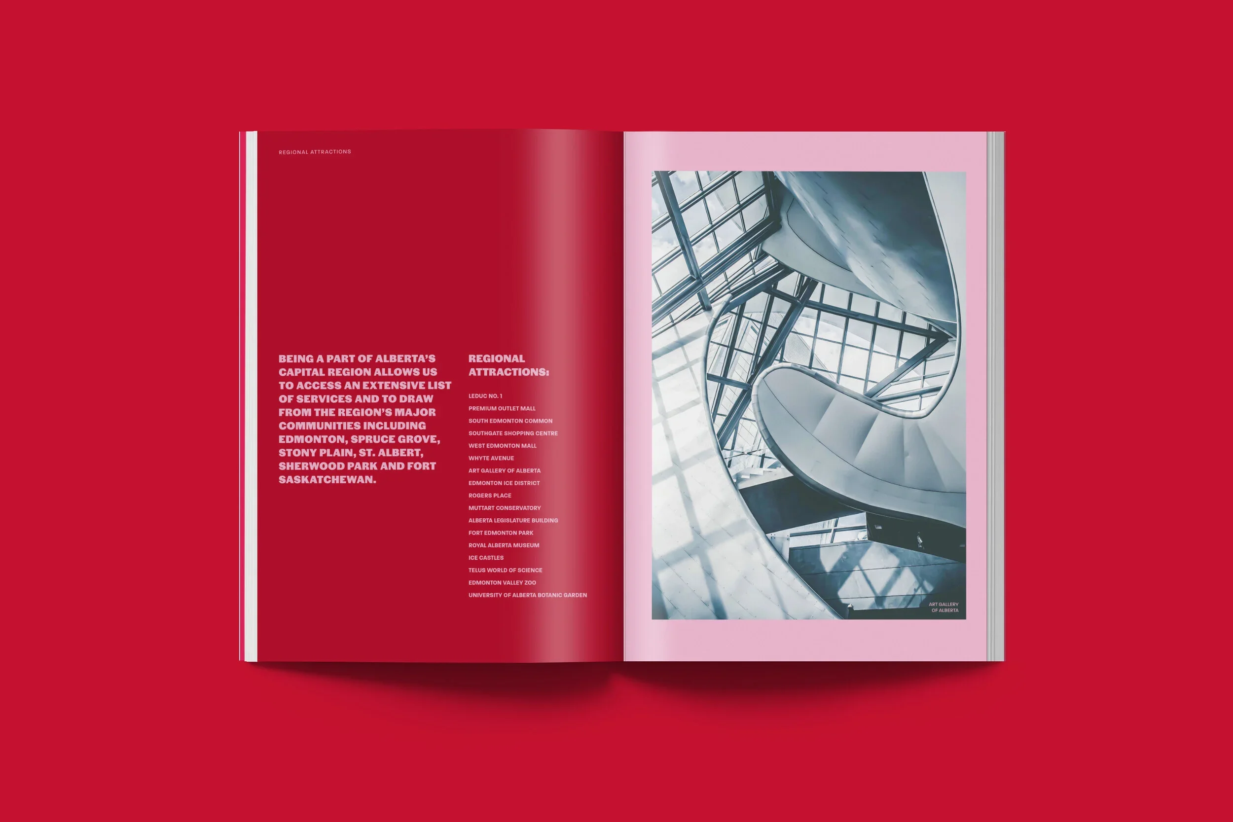 An open magazine with red and pink pages, featuring text on the left page about Alberta's regional attractions, and a photograph of an architectural interior with curved glass and metal structure on the right.