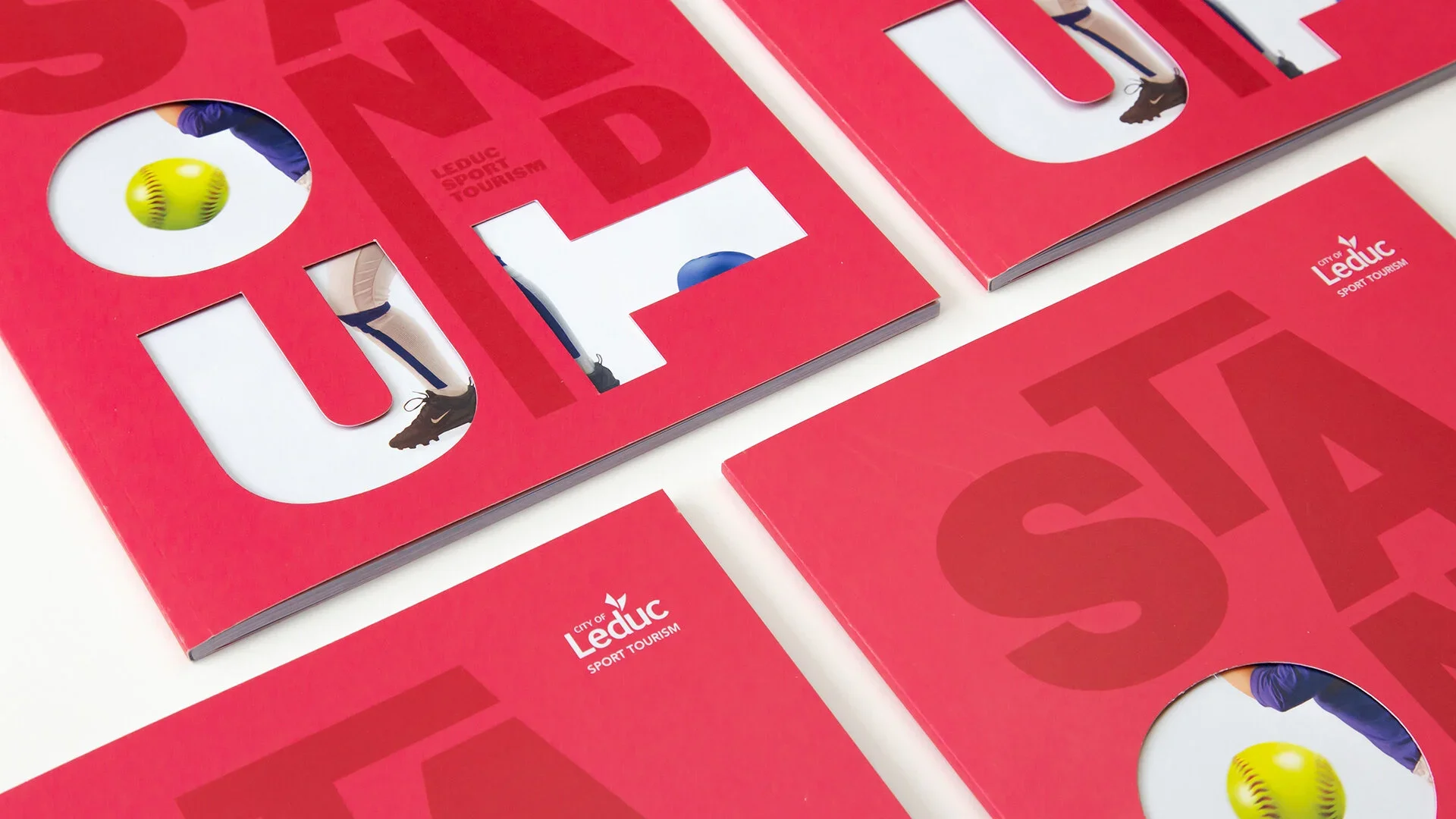 Red brochures with cutouts showing images of sports equipment and athletes, featuring the logo and text for City of Léduc Sport Tourism.