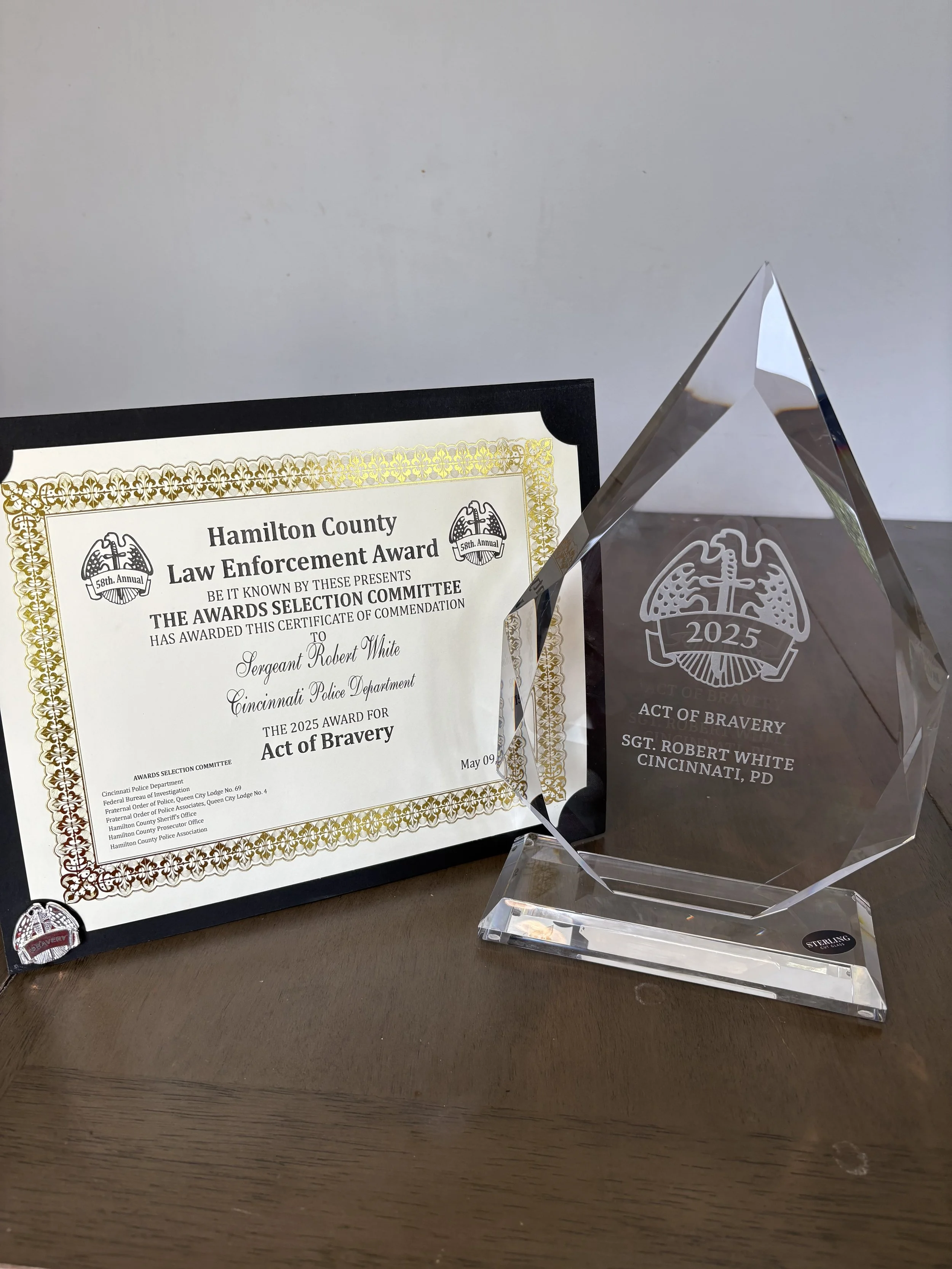 Certificate of commendation and glass award from Hamilton County Law Enforcement, recognizing Sergeant Robert White of Cincinnati Police Department for act of bravery in 2025.