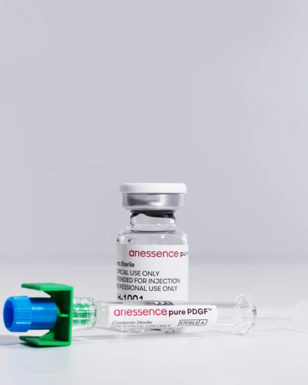 Vial of Ariessence Pure PDGF next to a prefilled syringe, used for microneedling treatments.