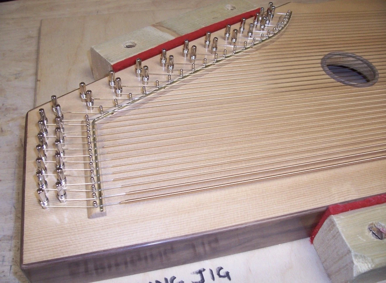 2nd view of harp after undergoing the polishing process, making and gluing on the bridges, installing the bridge pins, polished bridge caps and stringing up