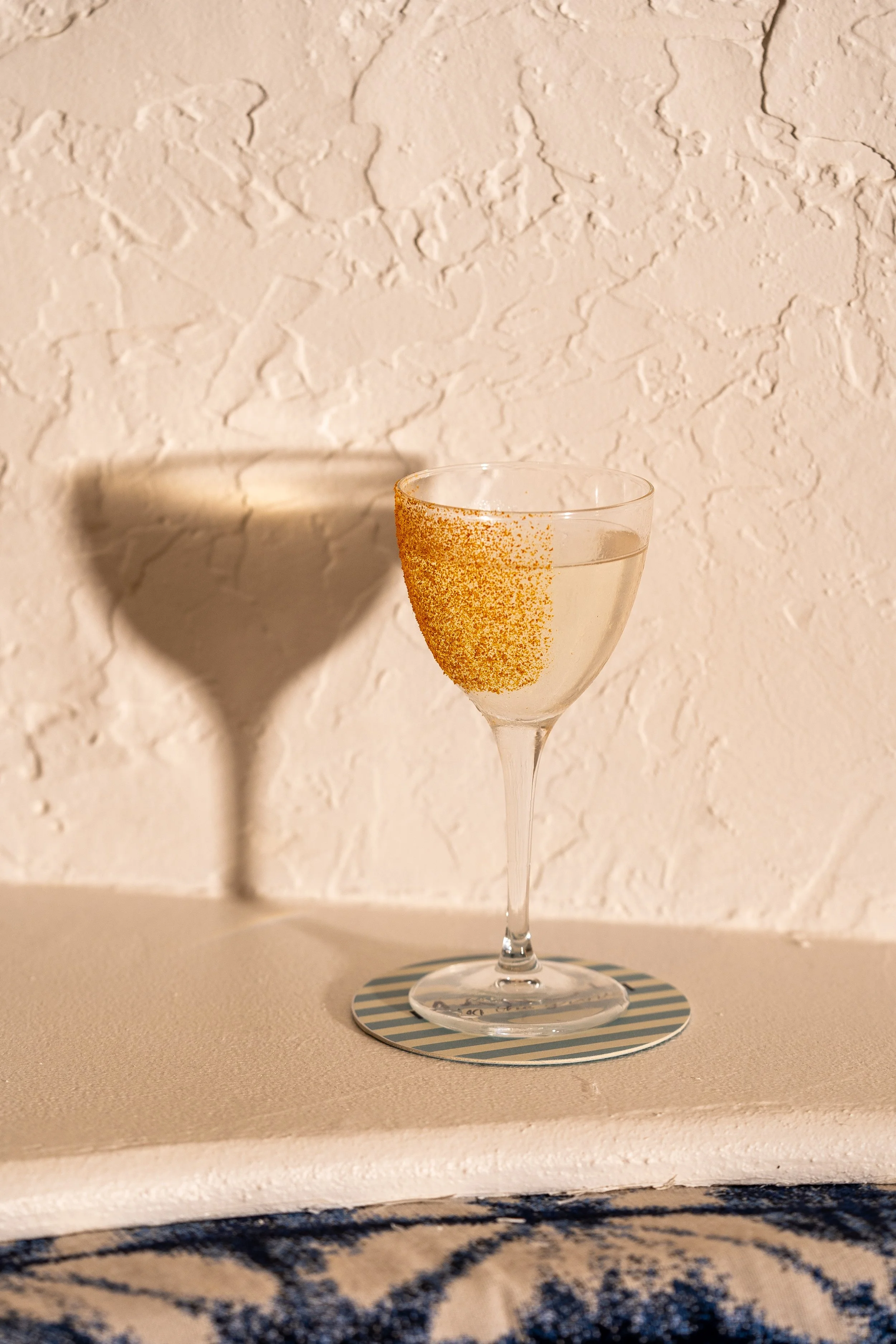 Cocktail made with jalapeño cilantro infused with tequila blanco, mandarin, blood orange, dukkah rim