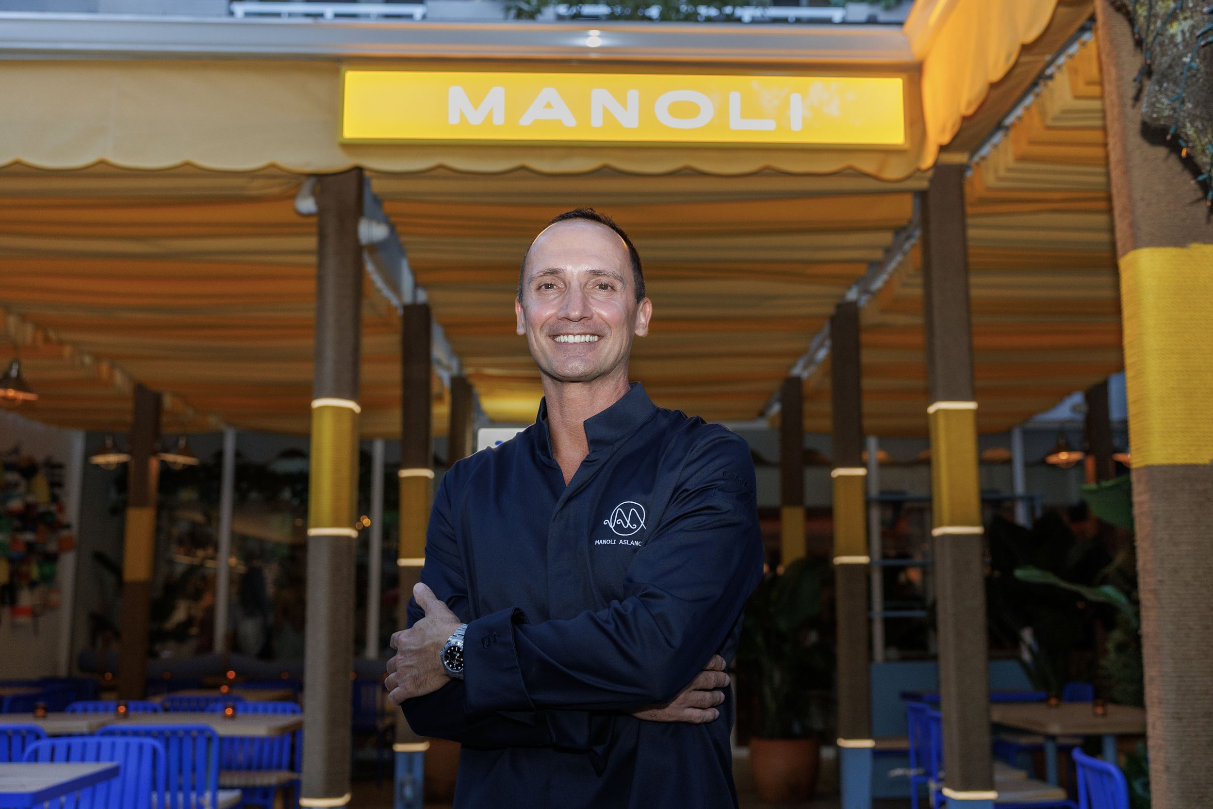 Chef Manoli in front of Manoli in the Grove storefront