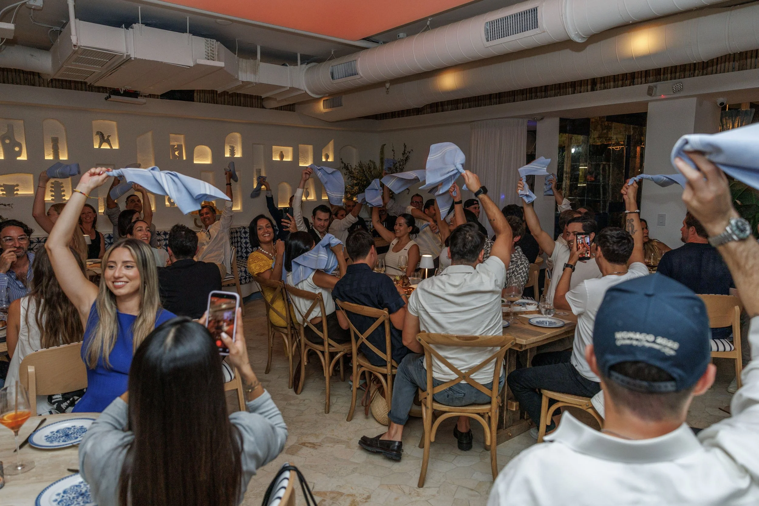 Guests enjoying food, cocktails, and music while twirling napkins