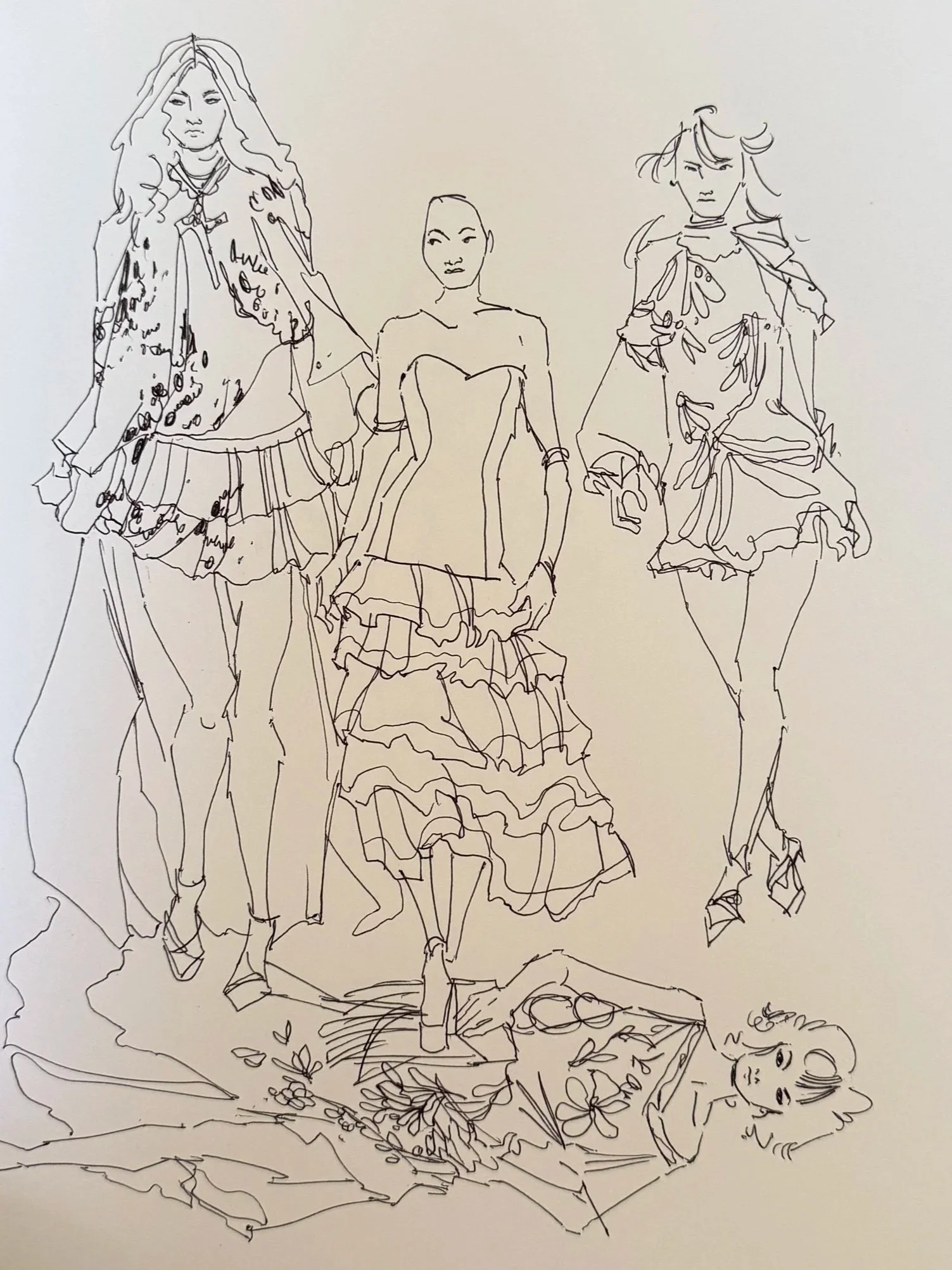 Sketch of three fashion models standing on a platform with a woman lying down in front, surrounded by flowers and decorative elements.