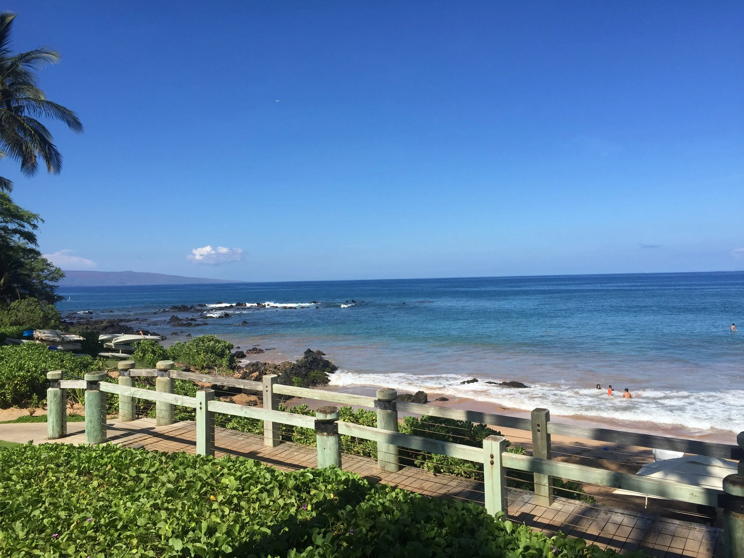 Pacific Morning (Open Ocean View): The first light of day illuminates crystal-clear waters where gentle waves meet volcanic shoreline beneath expansive island skies. Clean lines, vivid blues, and natural simplicity create an image that evokes optimis