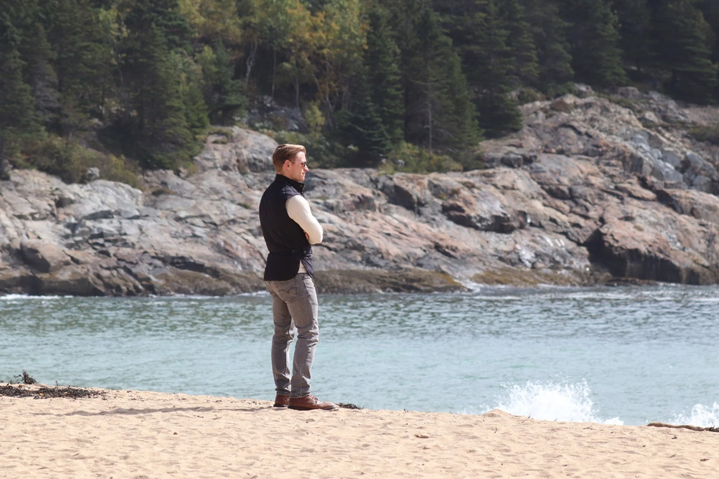 Contemplation at the Water's Edge

A solitary figure stands on a quiet stretch of sand, facing the cool blue waters and rugged granite shoreline beyond. The human presence introduces scale and introspection, transforming the coastal landscape into a 