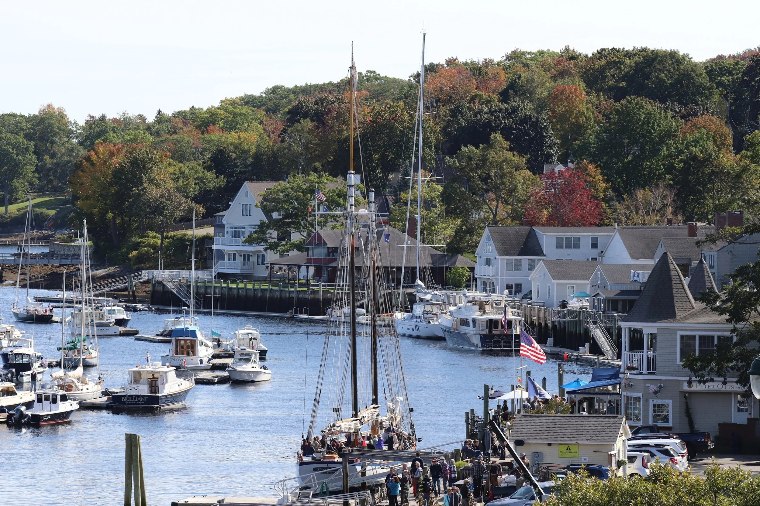 Harbor Life - Autumn in a Maine Coastal Village: Boats, waterfront buildings, and early autumn color come together in a scene that celebrates the charm and vitality of a working coastal village. The image offers a strong sense of place and regional i
