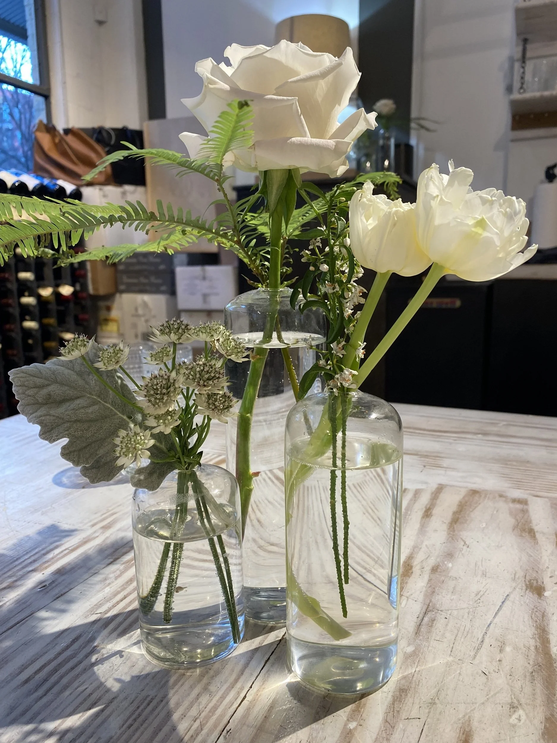 Quiet Arrangement: Delicate white blooms arranged in simple glass vessels celebrate the beauty of understated design and thoughtful detail. Soft natural light and organic textures make this image well-suited for boutique hotels, spas, cafés, receptio