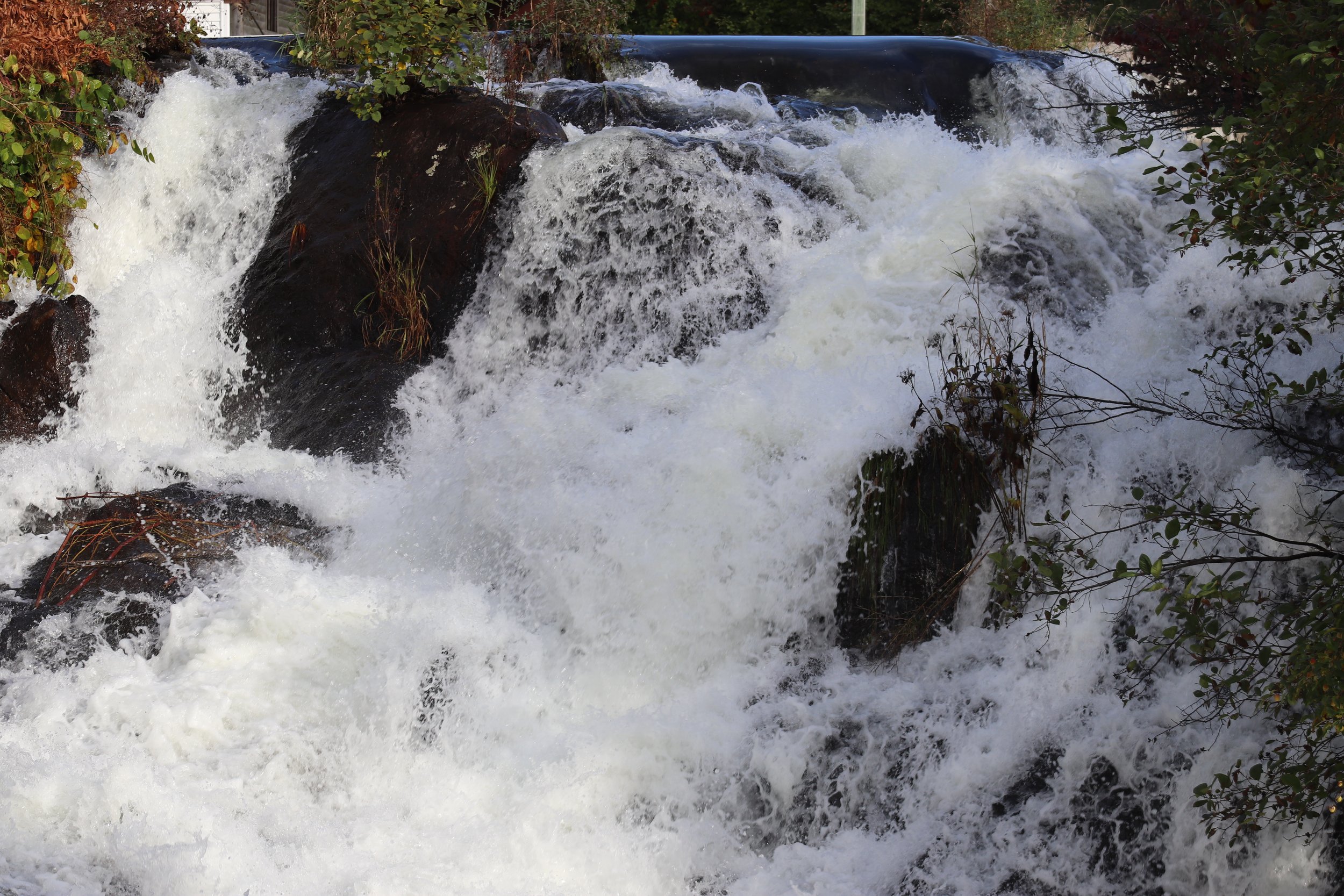 White Cascade: A closer study of cascading water reveals the sculptural beauty of rushing currents as they tumble over weathered stone. The interplay of movement, texture, and light creates an abstract natural composition that is both energetic and c