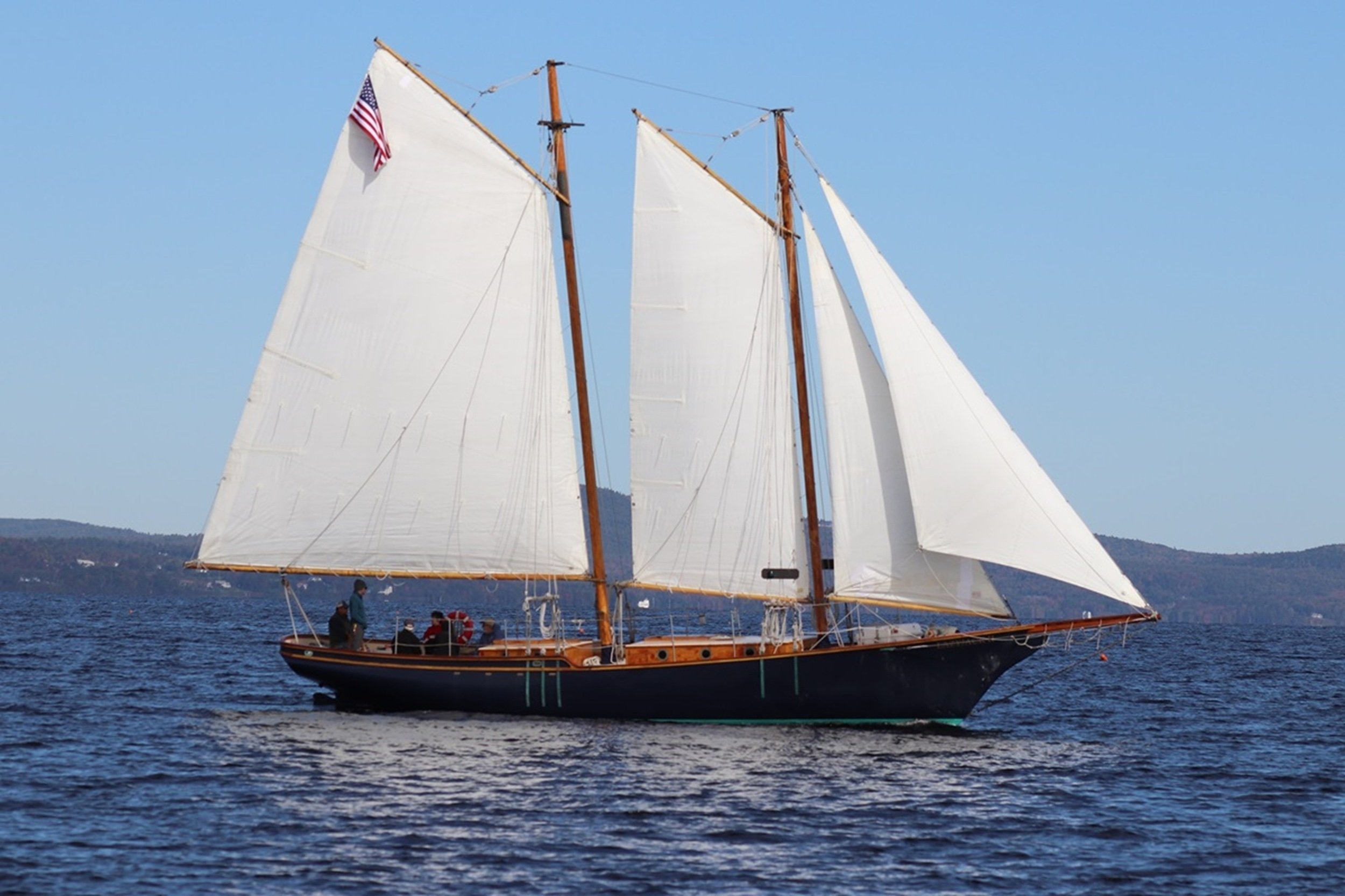 Under Full Sail: A beautifully restored schooner glides across open water beneath a full spread of sails, embodying freedom, tradition, and the enduring spirit of coastal exploration. This image brings a strong sense of place and timeless maritime el