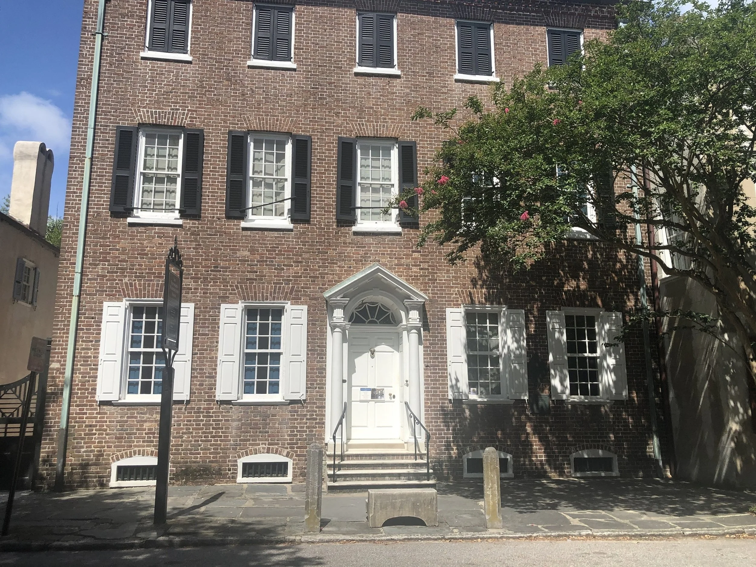 Timeless Facade: A stately brick building with symmetrical windows and classic architectural proportions reflects the enduring character of historic Charleston. The balance of form, texture, and heritage makes this image an excellent fit for boutique