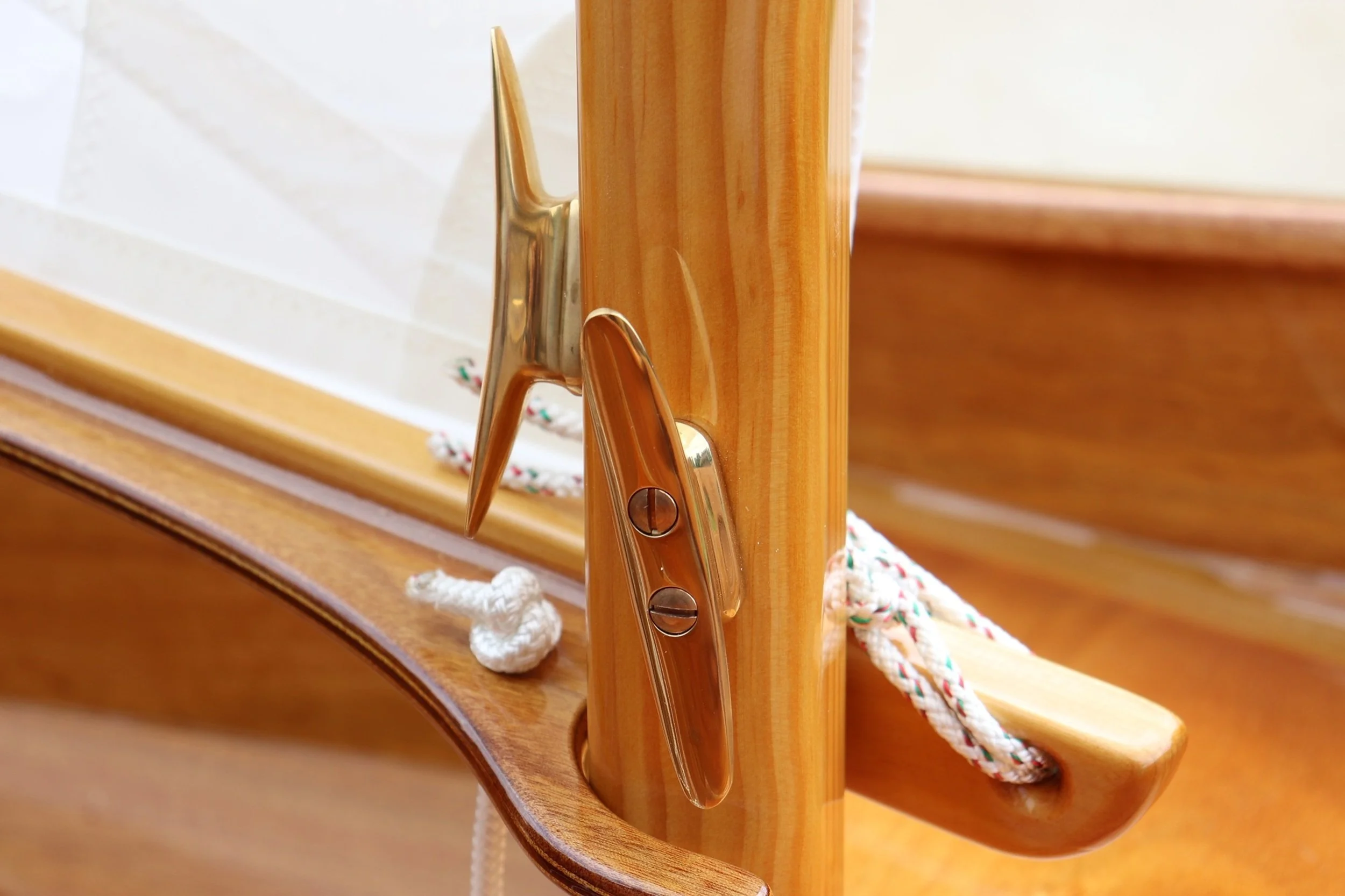 Crafted Calm: Warm wood grain polished bronze hardware, and carefully arranged rigging showcase the quiet beauty of traditional boatbuilding. The image conveys craftsmanship, balance, and understated luxury, making it well suited for guest rooms, lib