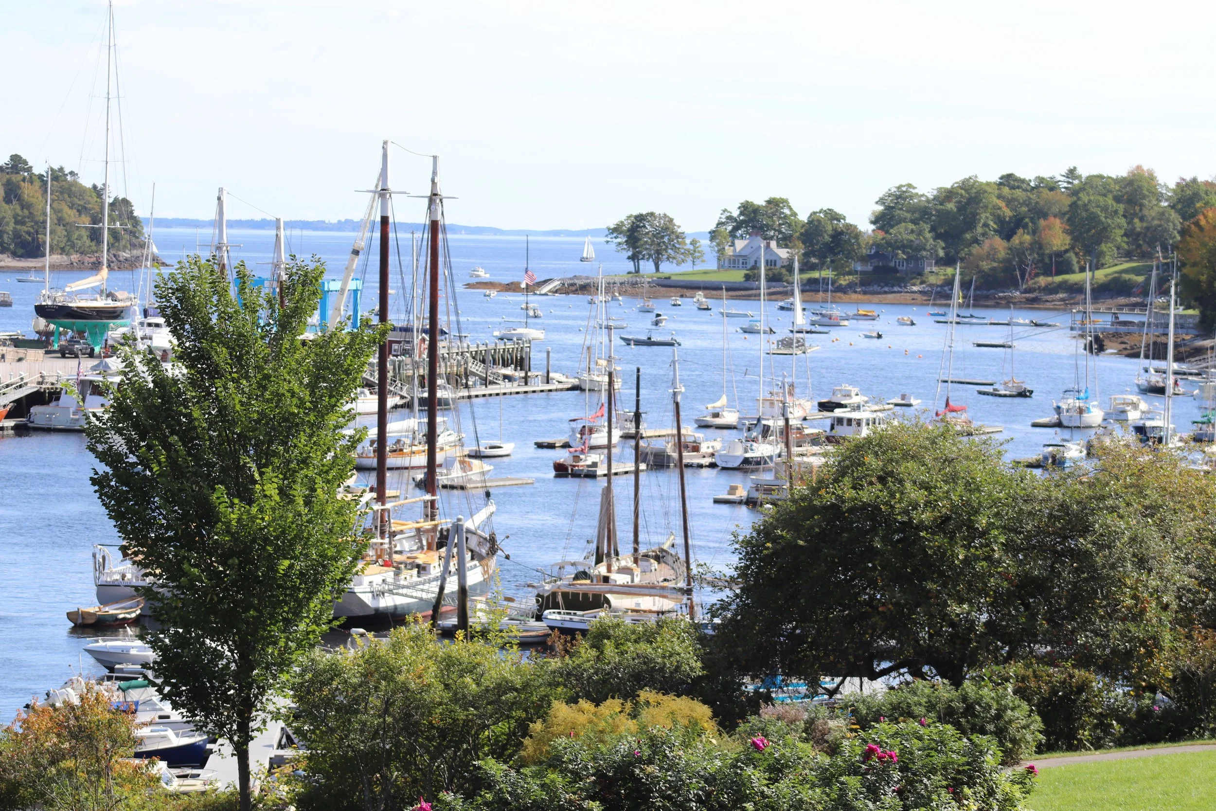 Harbor Morning (Camden Harbor): Morning light settles over a vibrant harbor where sailboats, working vessels, and waterfront gardens come together in perfect balance. Rich maritime detail and layered textures create an inviting composition that refle