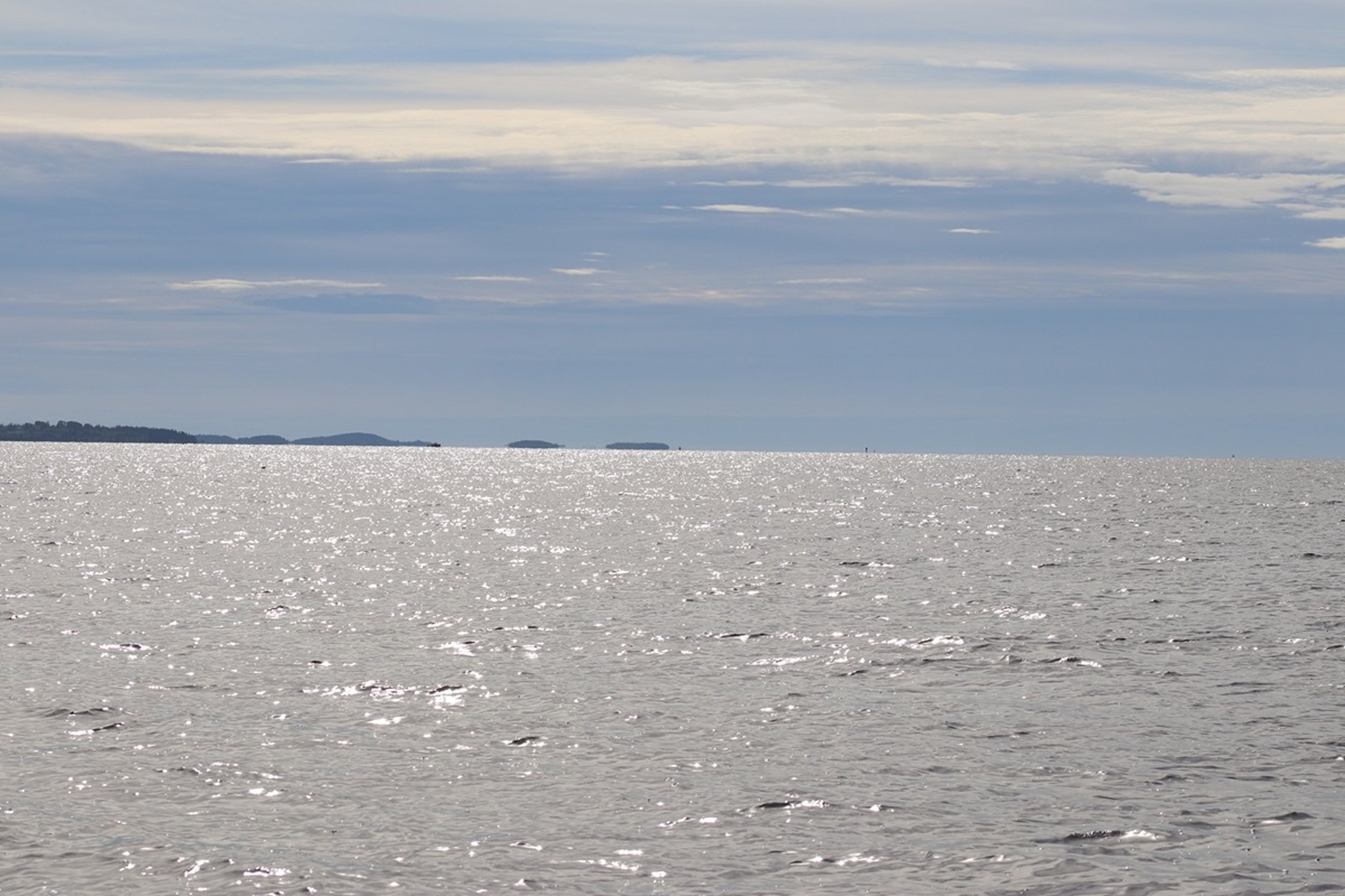 Silver Horizons - Light Across Penobscot Bay: Sunlight dances across Penobscot Bay's surface beneath layered coastal skies, creating a luminous, contemplative seascape. The image's calming palette and expansive horizon make it especially suited for g