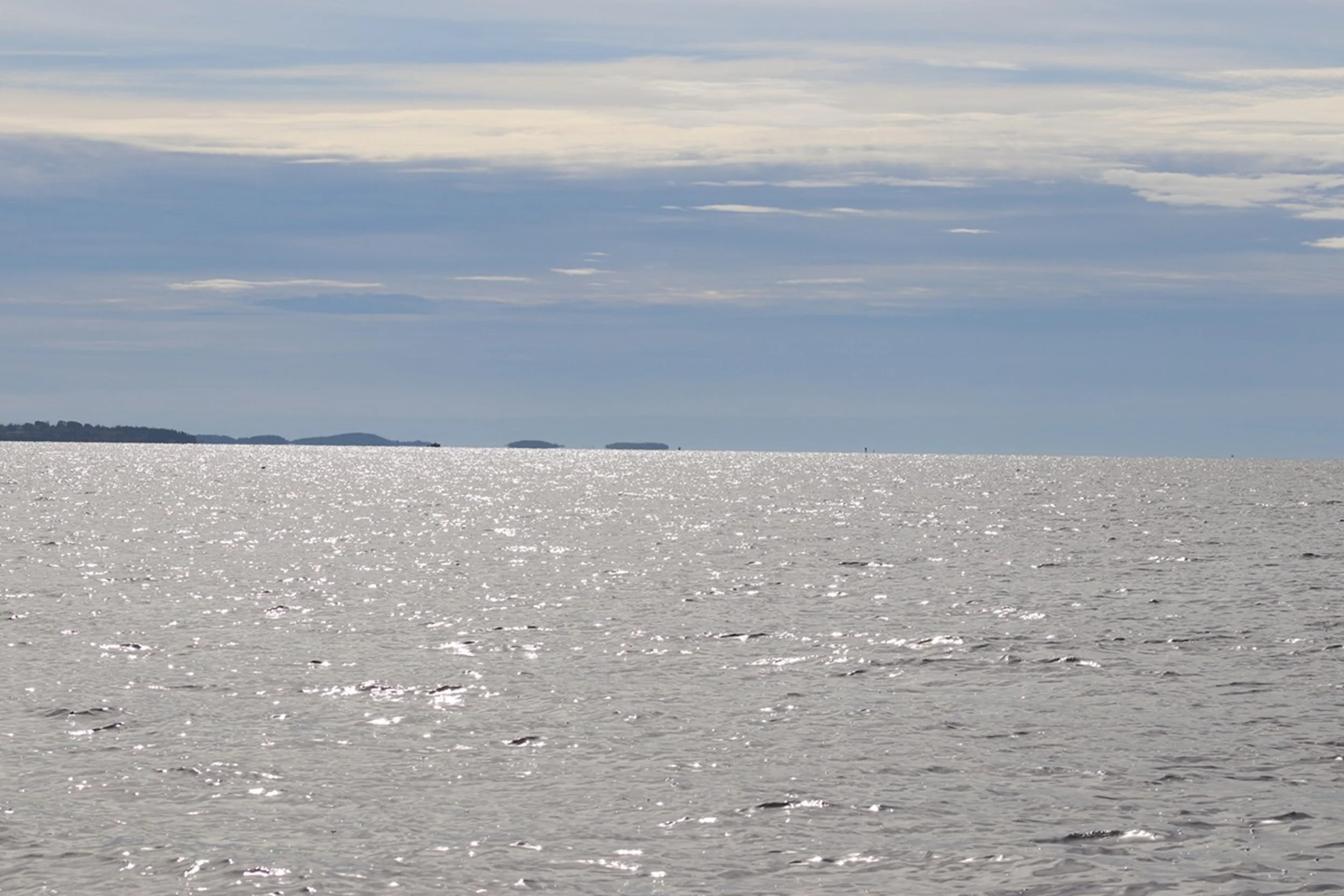 Silver Horizon - Light Across Penobscot Bay

A luminous expanse of water stretches toward distant islands beneath a layered sky. Soft reflections shimmer across the surface, creating a minimalist coastal study defined by openness, light, and atmosphe
