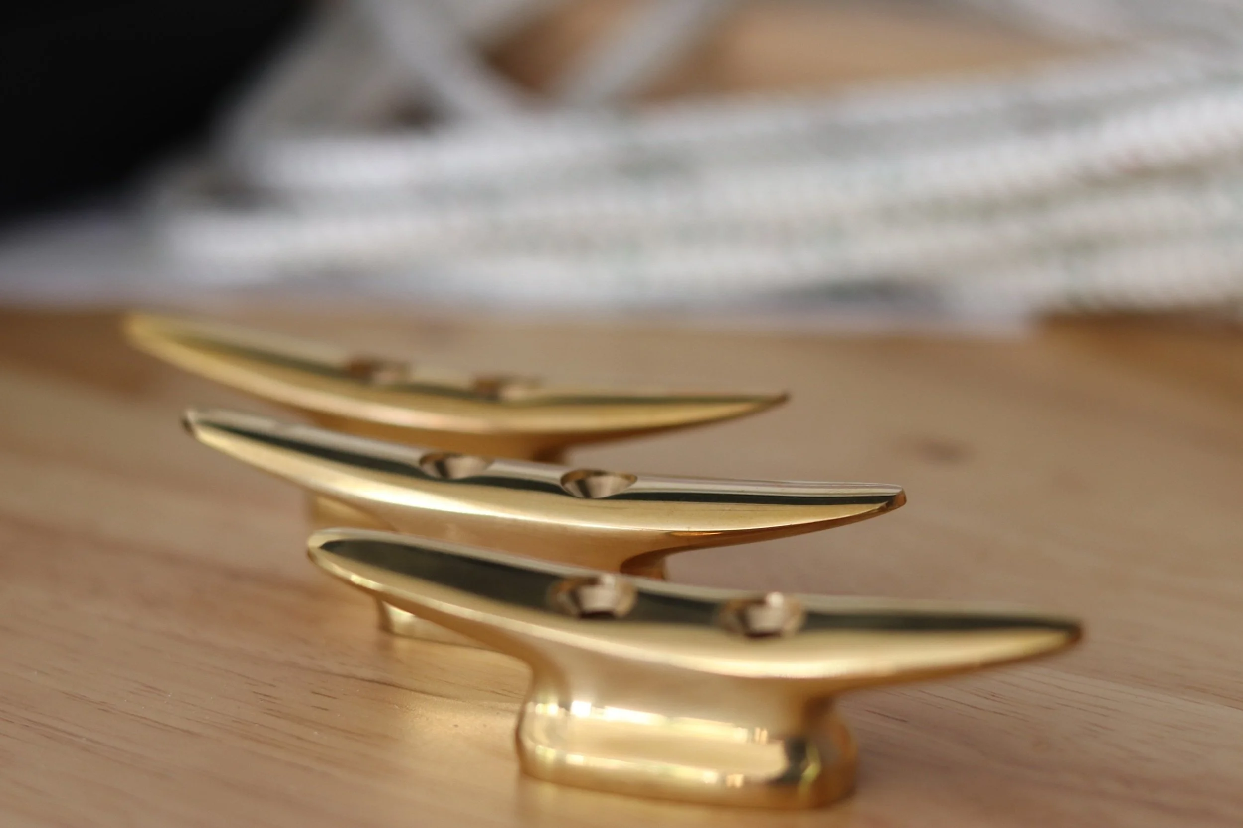 Close-up of gold-colored forks stacked on a wooden surface.