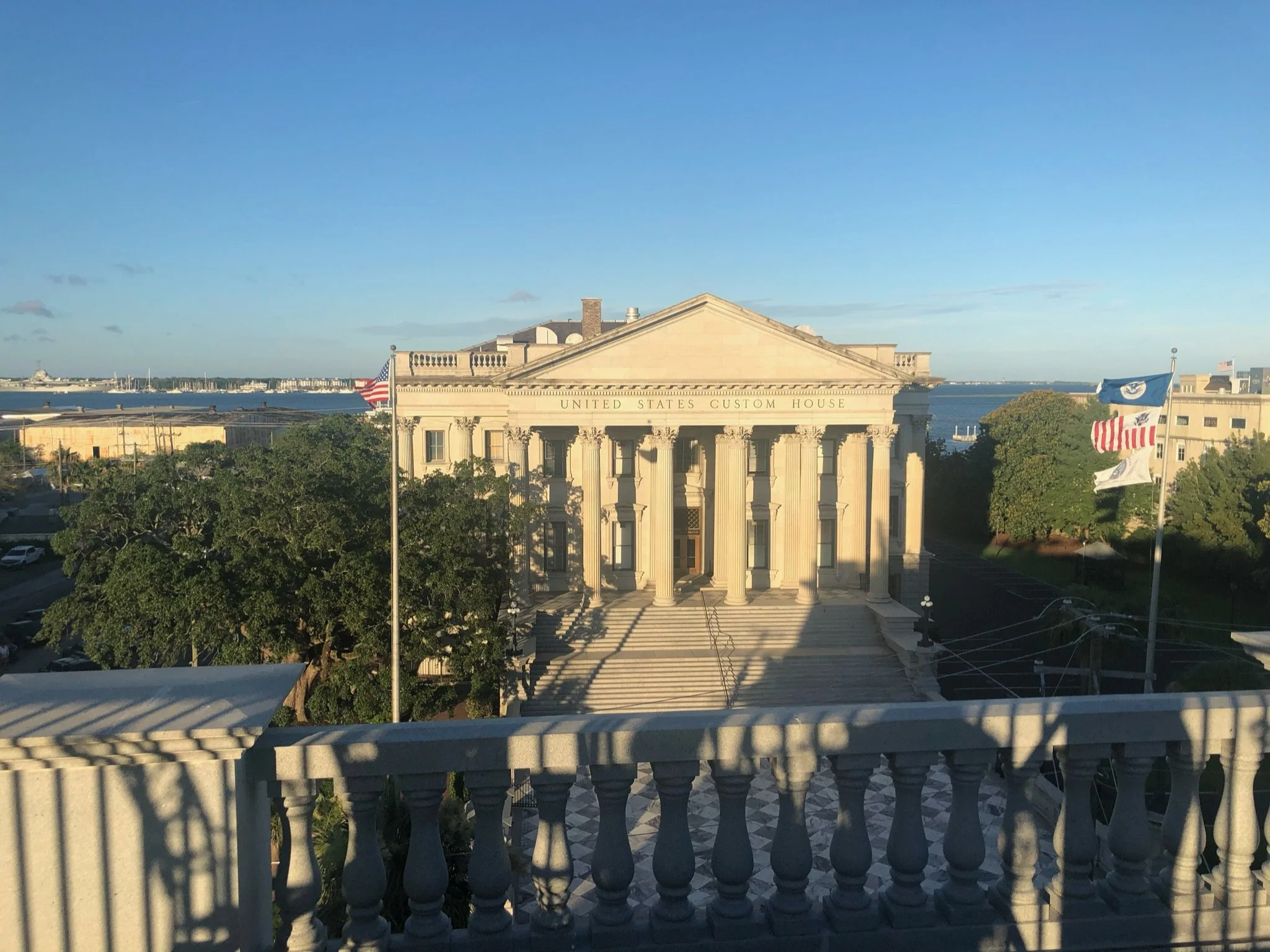 Guardian of the Harbor: Standing prominently above Charleston Harbor, the historic United States Custom House reflects the city's enduring maritime heritage and neoclassical elegance. Warm evening light accentuates its grand columns and balanced prop