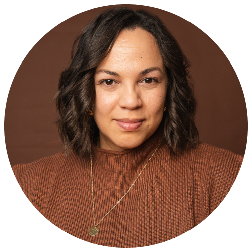 Retrato de una mujer con cabello rizado y blusa marrón, con fondo marrón.