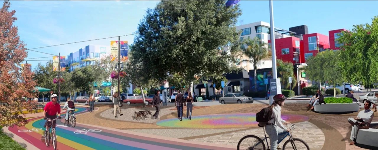 A vibrant urban park with people riding bikes, walking, and socializing on colorful pathways, surrounded by trees and modern buildings.