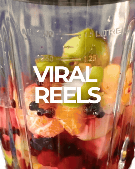 A blender jar filled with assorted fruits including strawberries, blueberries, grapes, a pineapple slice, and a banana, with the text "VIRAL REELS" overlayed.